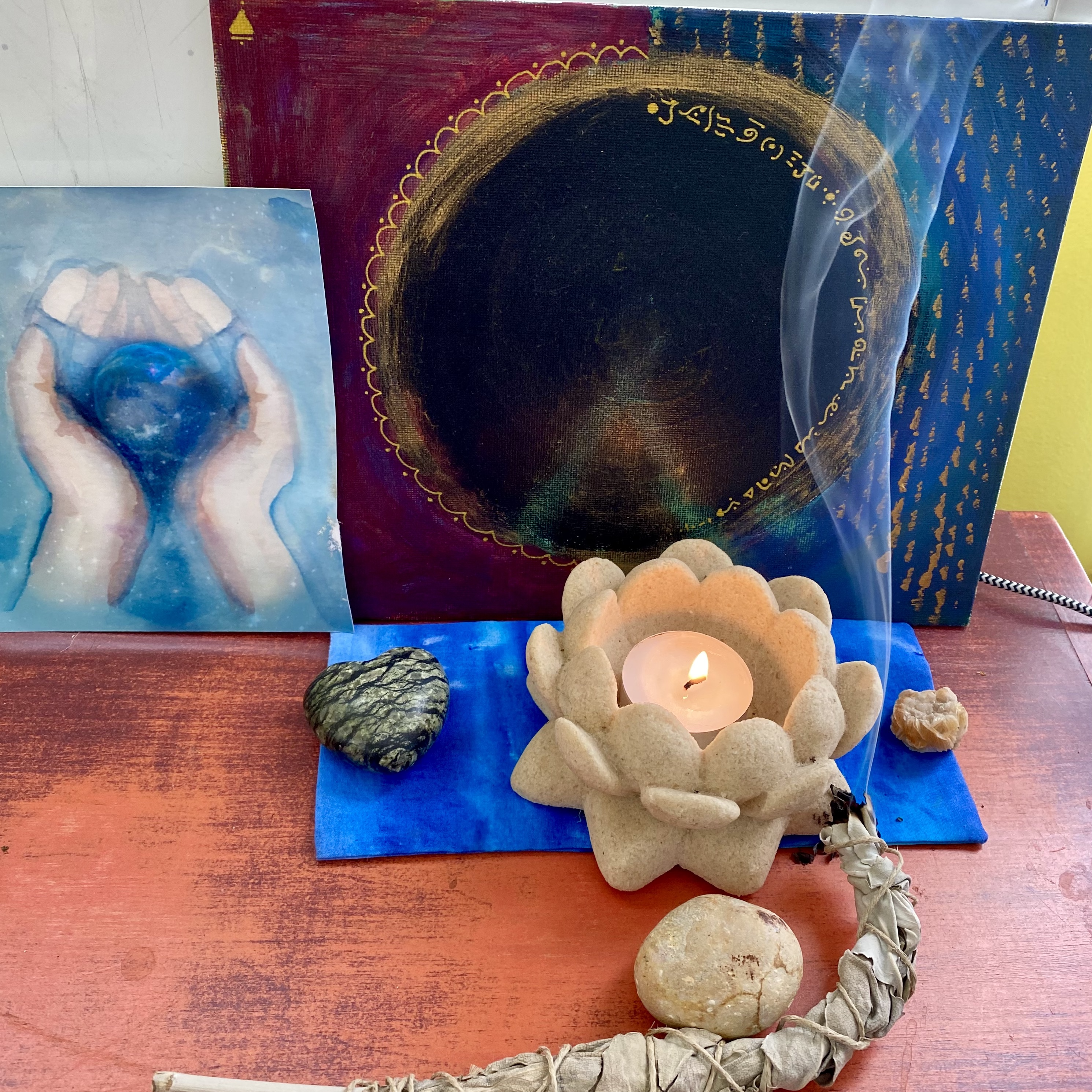 Divine Mother Altar with a painting, candle and burning sage