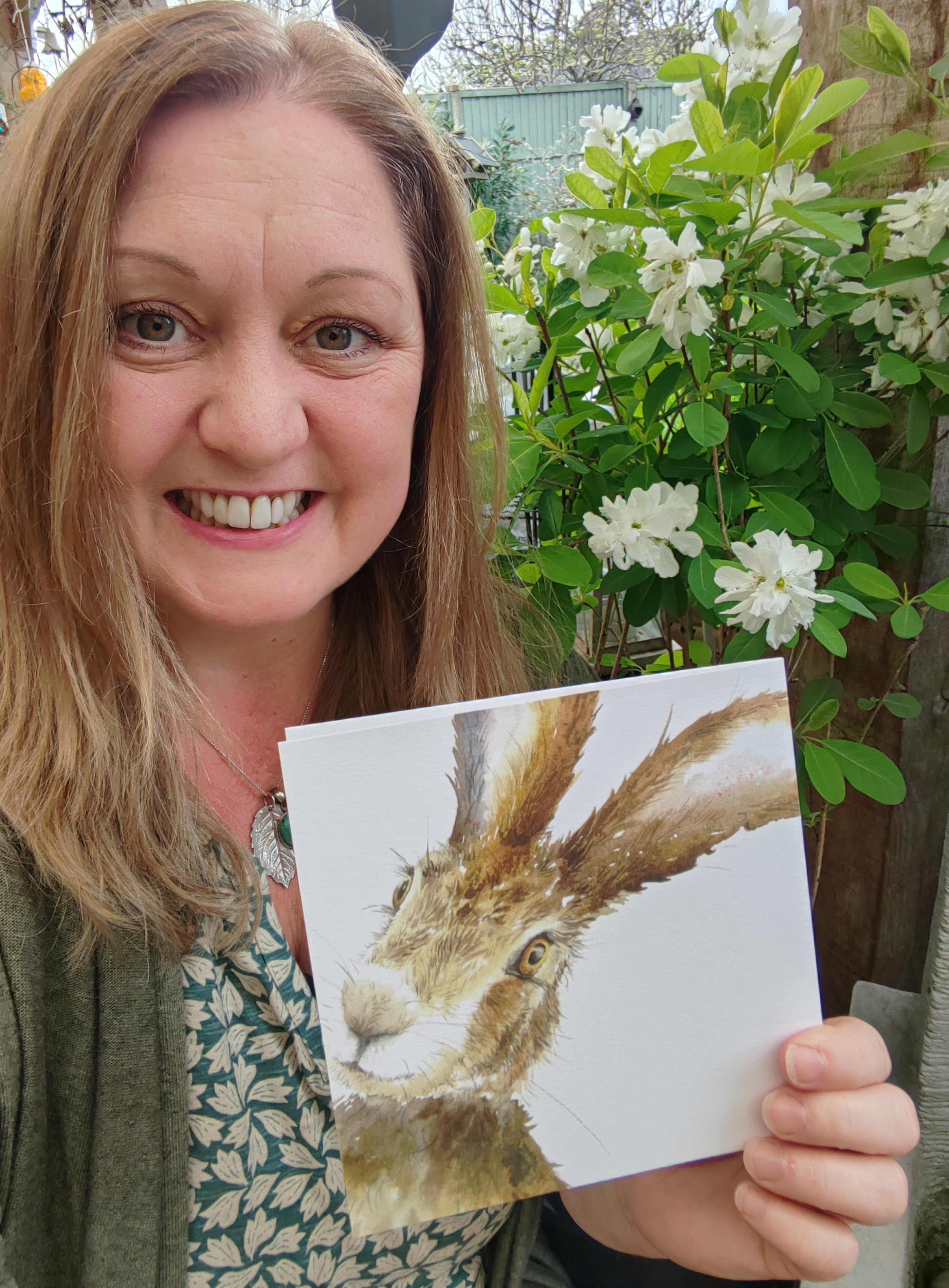 sarah reilly artist holding up a hare card