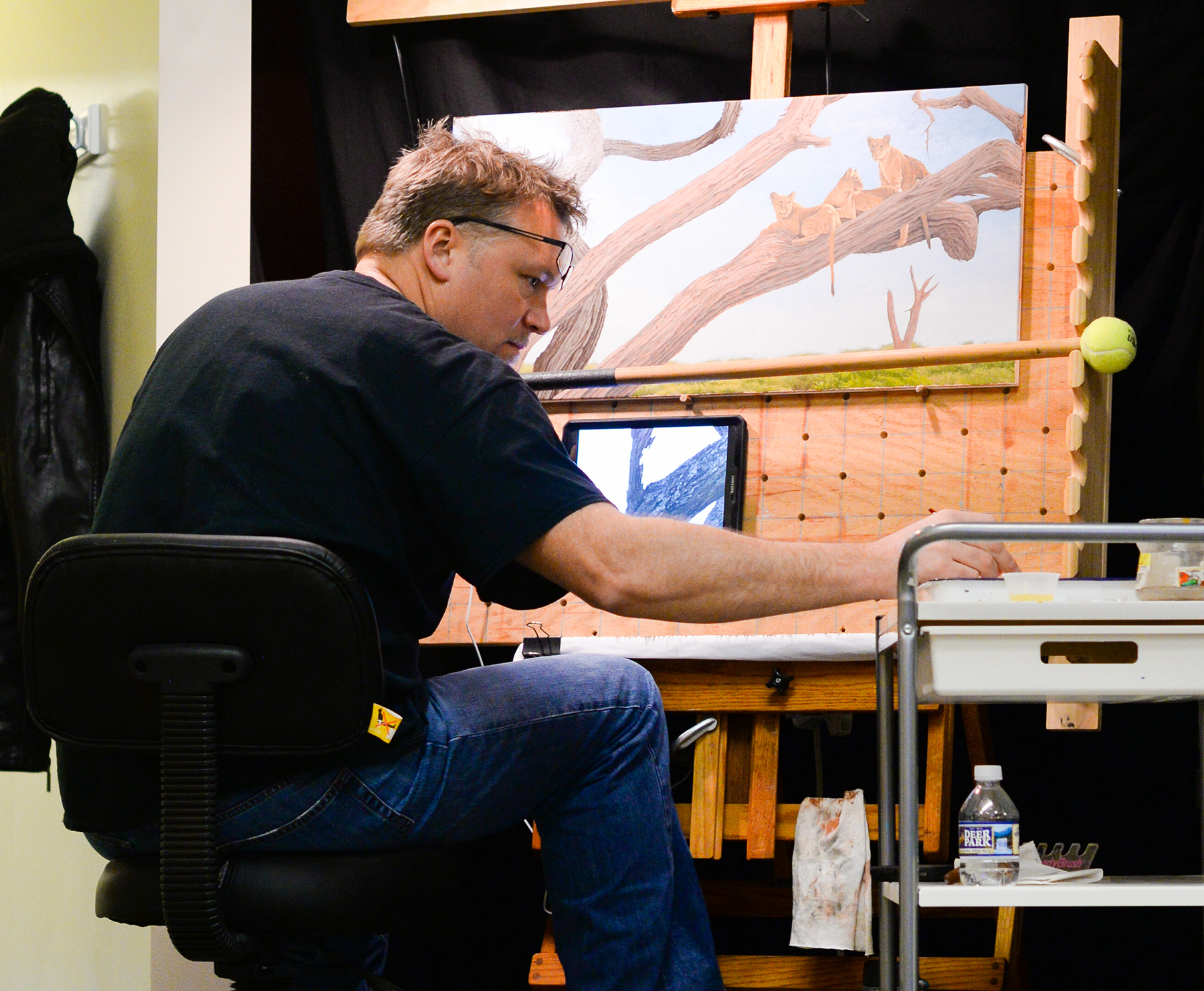 Artist Robert Louis Caldwell working on a oil painting of lions