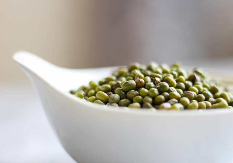 Mung beans in a white bowl.