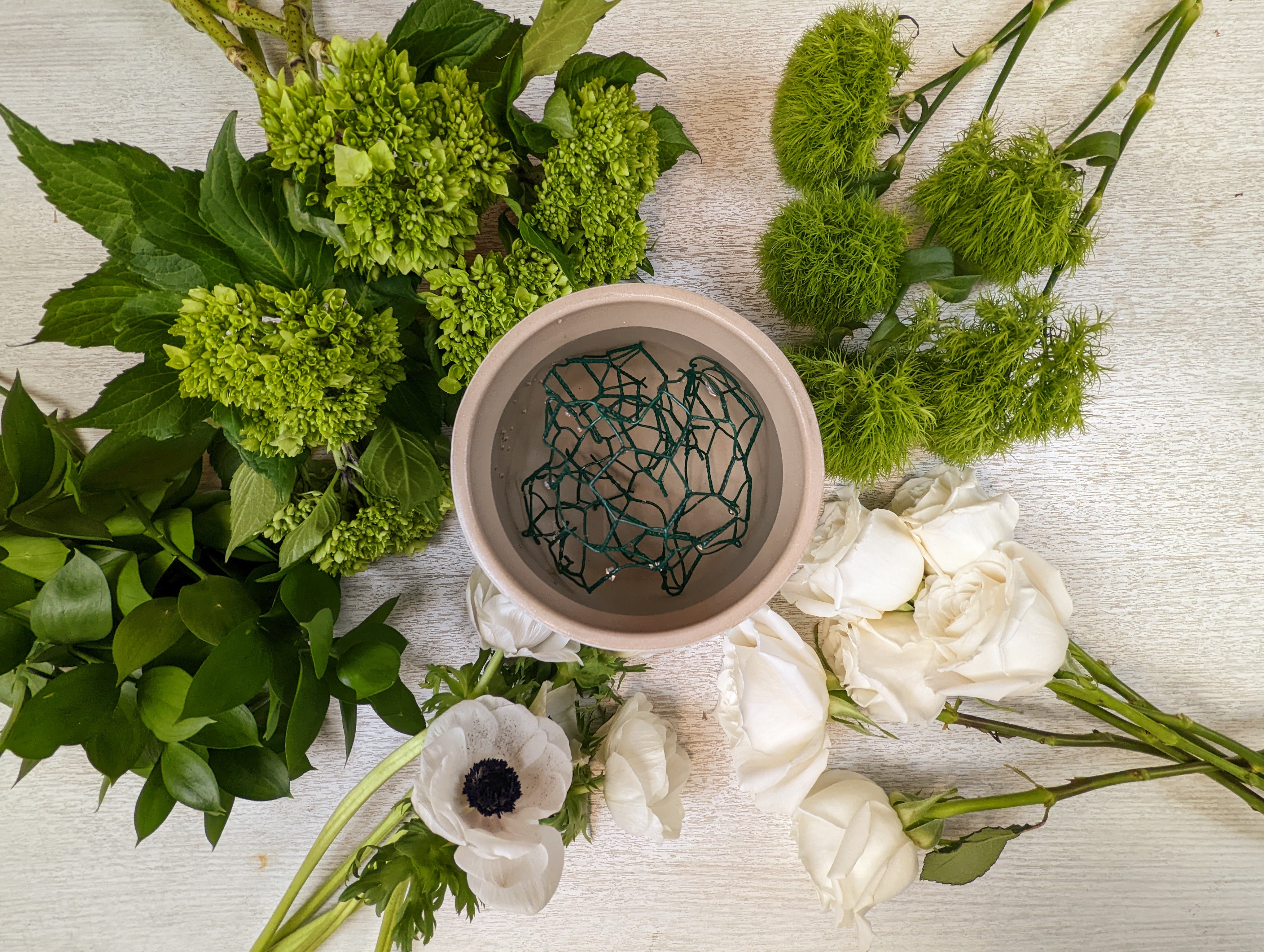 Green Texture flowers, white roses and a bowl with chicken wire in it