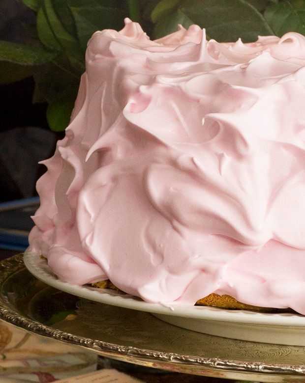 An angel food cake is on display with light pink frosting.