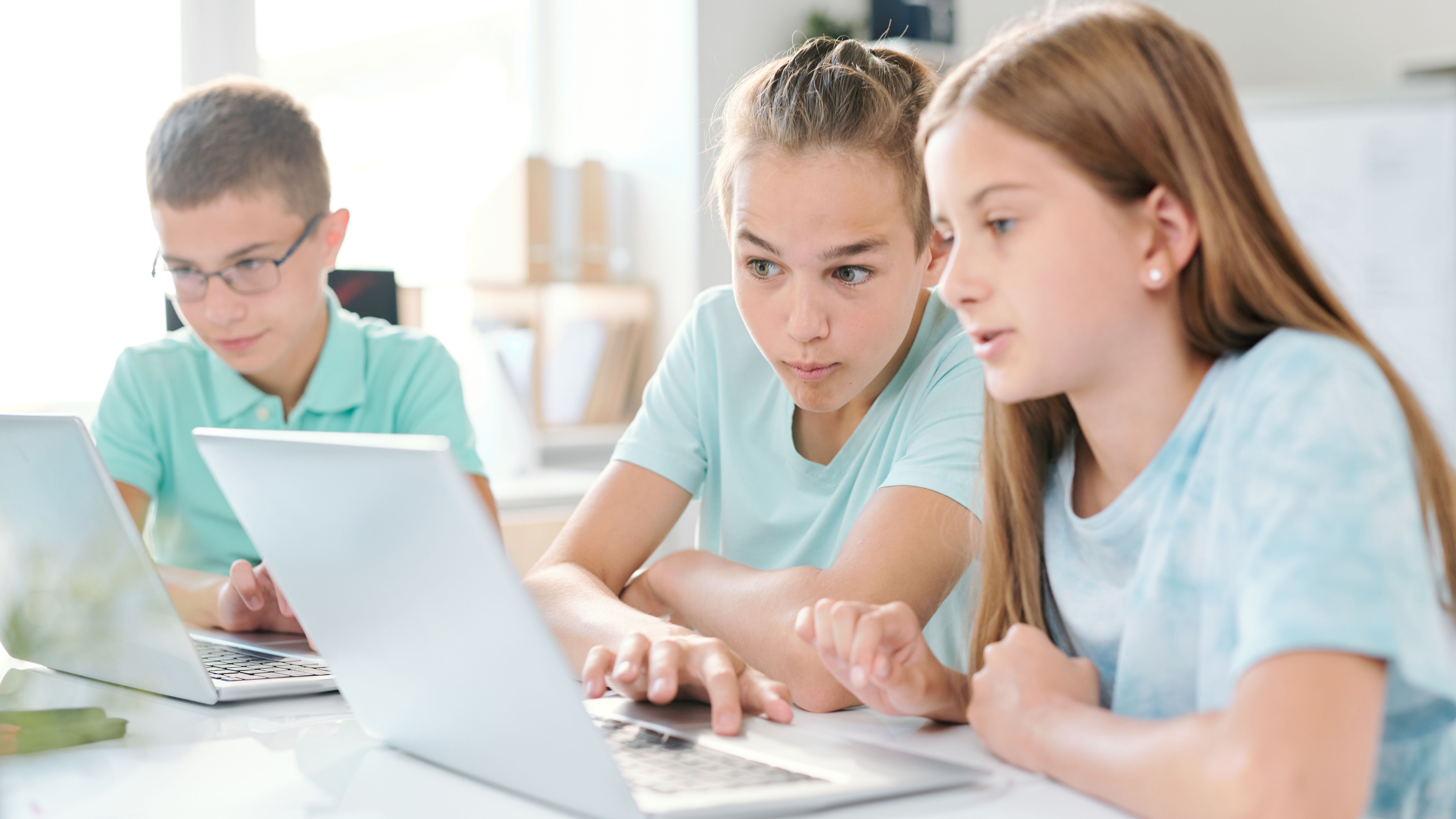 two students working together in front of a laptop