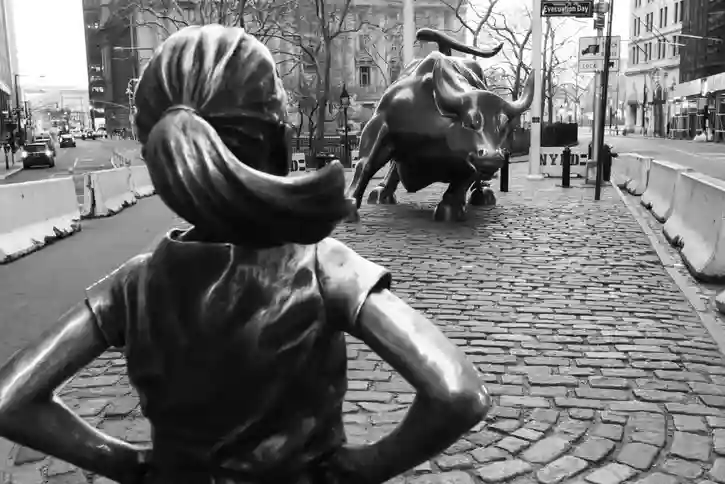 Wall Street statue of bull and a small girl. Photo by Daniel Lloyd