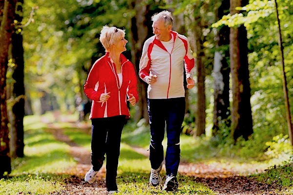 Man and woman out on a run through woodland