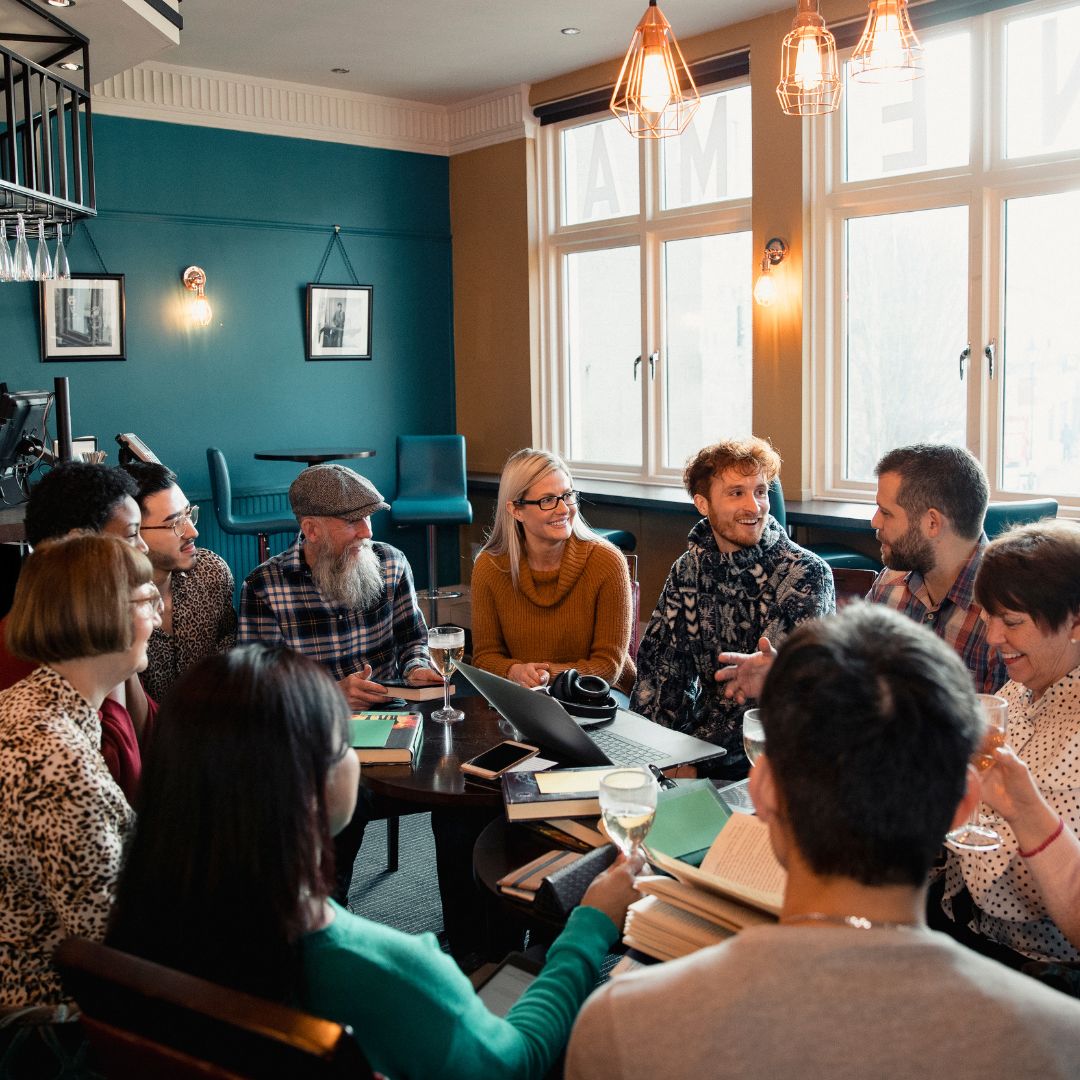 Group of people talking at a cafe over drinks.