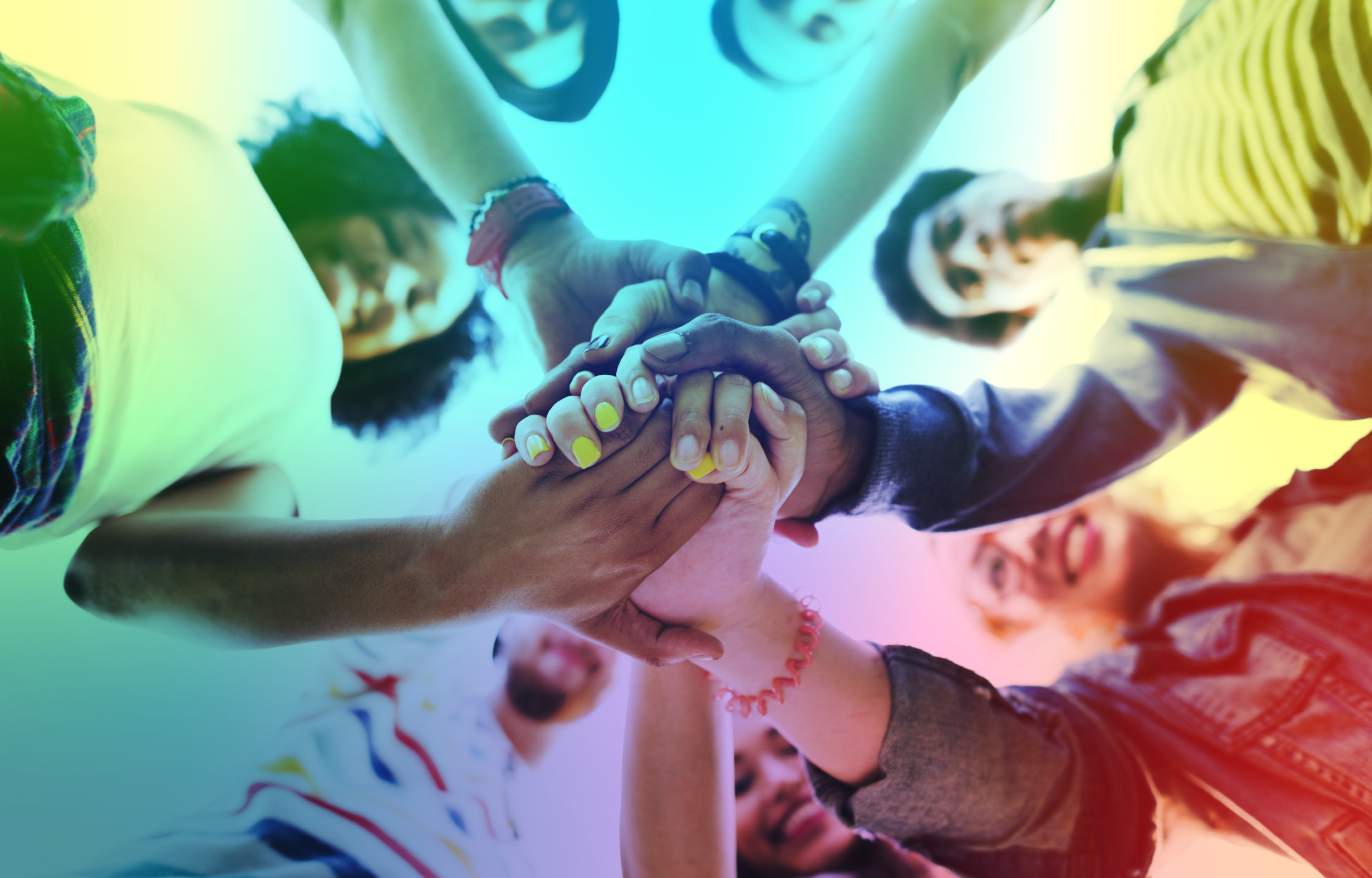 A diverse group of people standing in a circle holding hands.