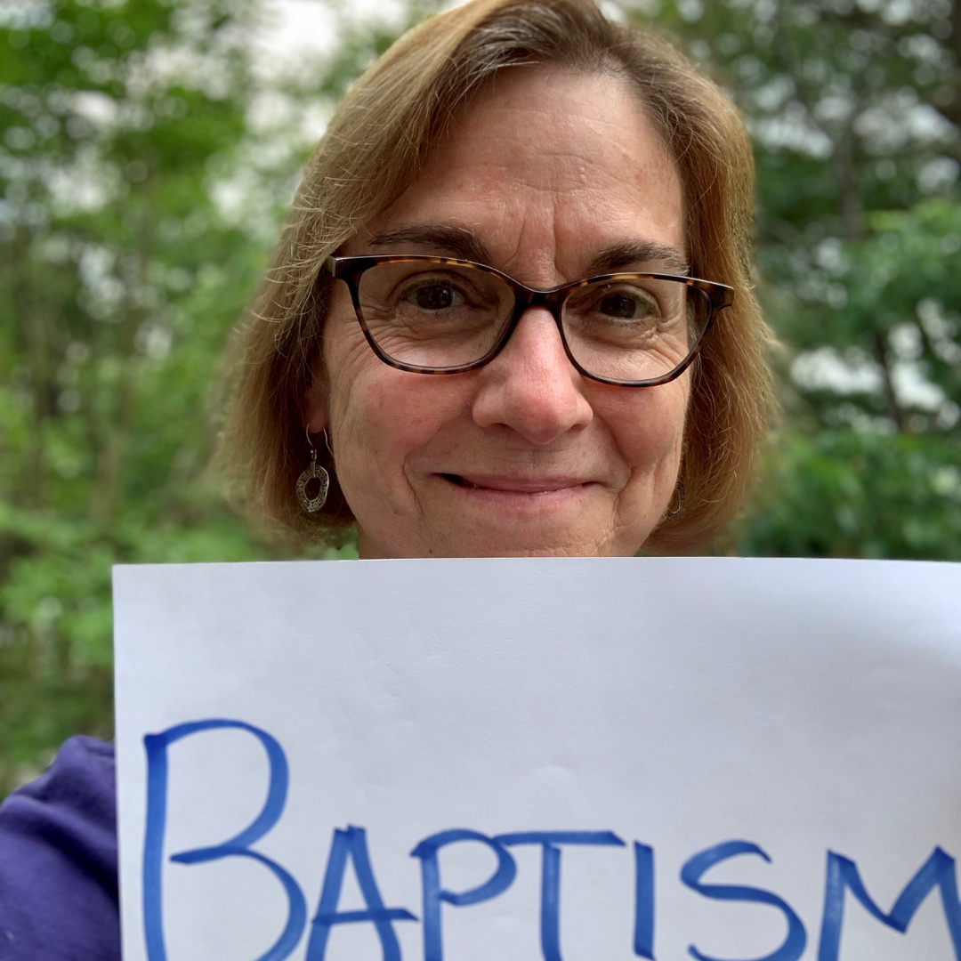 Lisa Kimball in front of greenery with a sign saying 