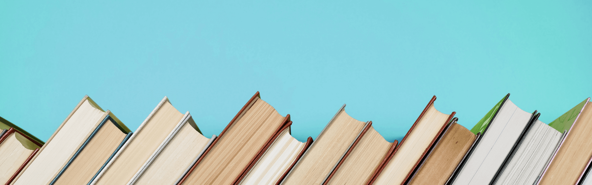 Row of books leaning to the side against blue wall