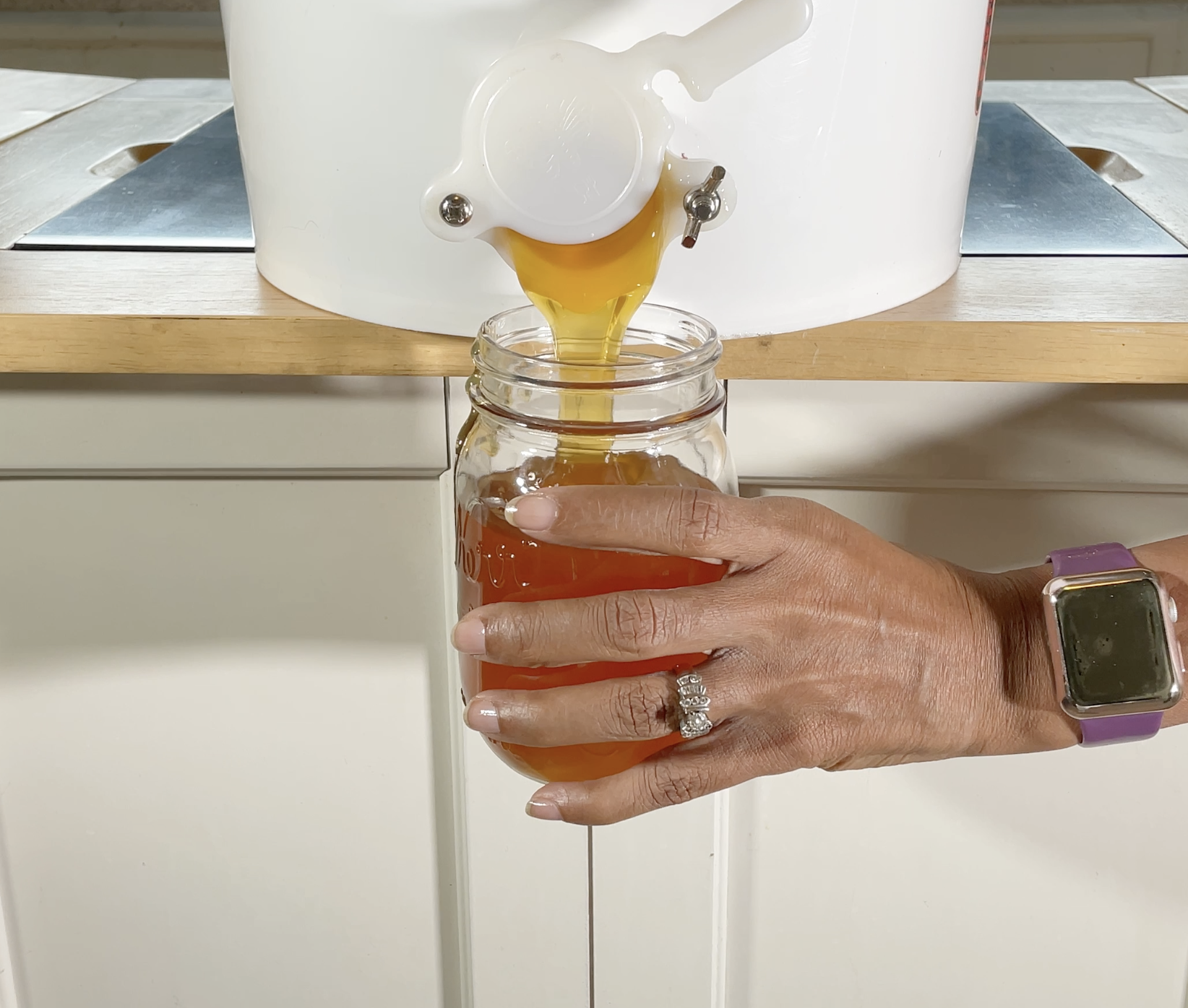 raw natural honey being poured in mason jar at home