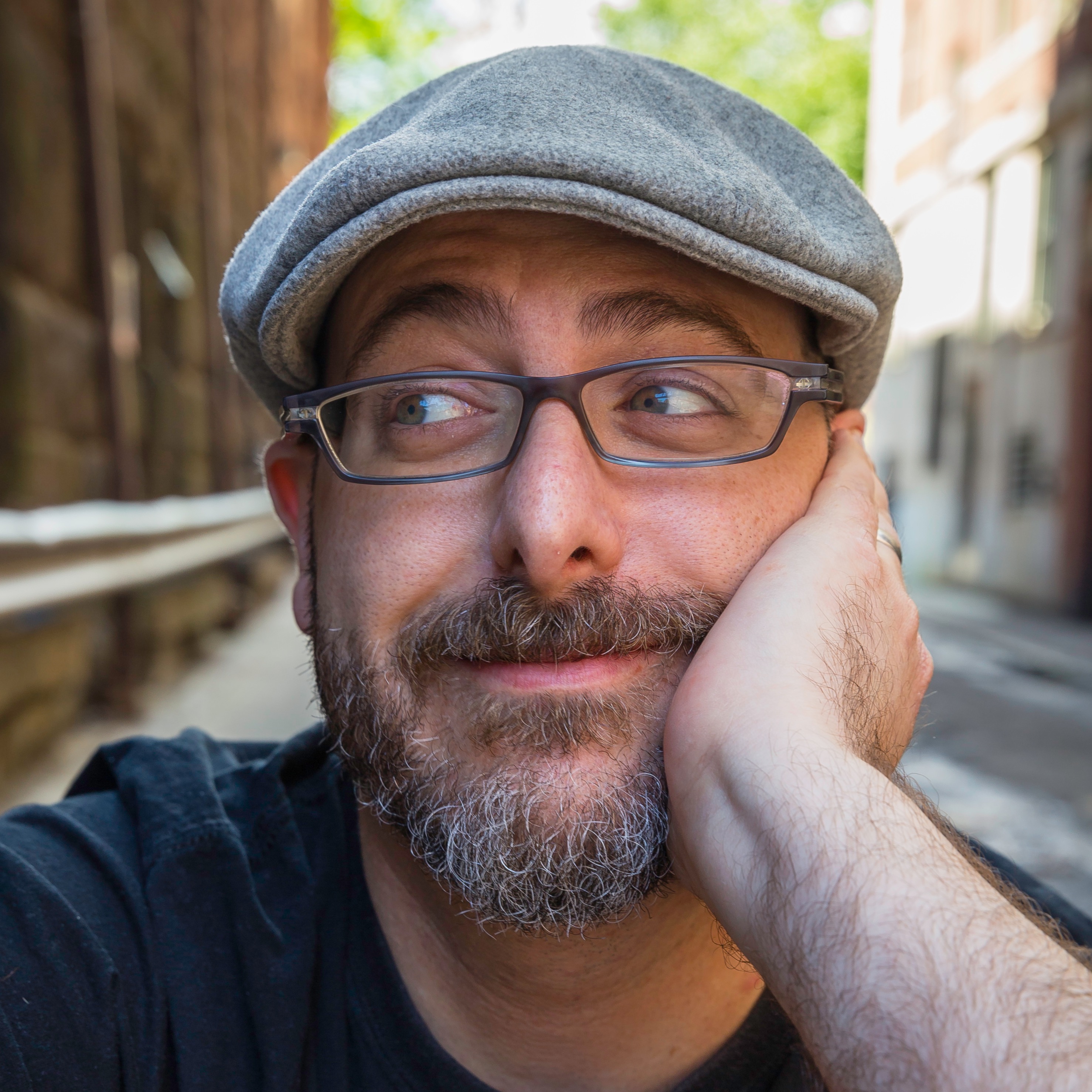 A picture of author Josh Funk in a beret looking to the left.