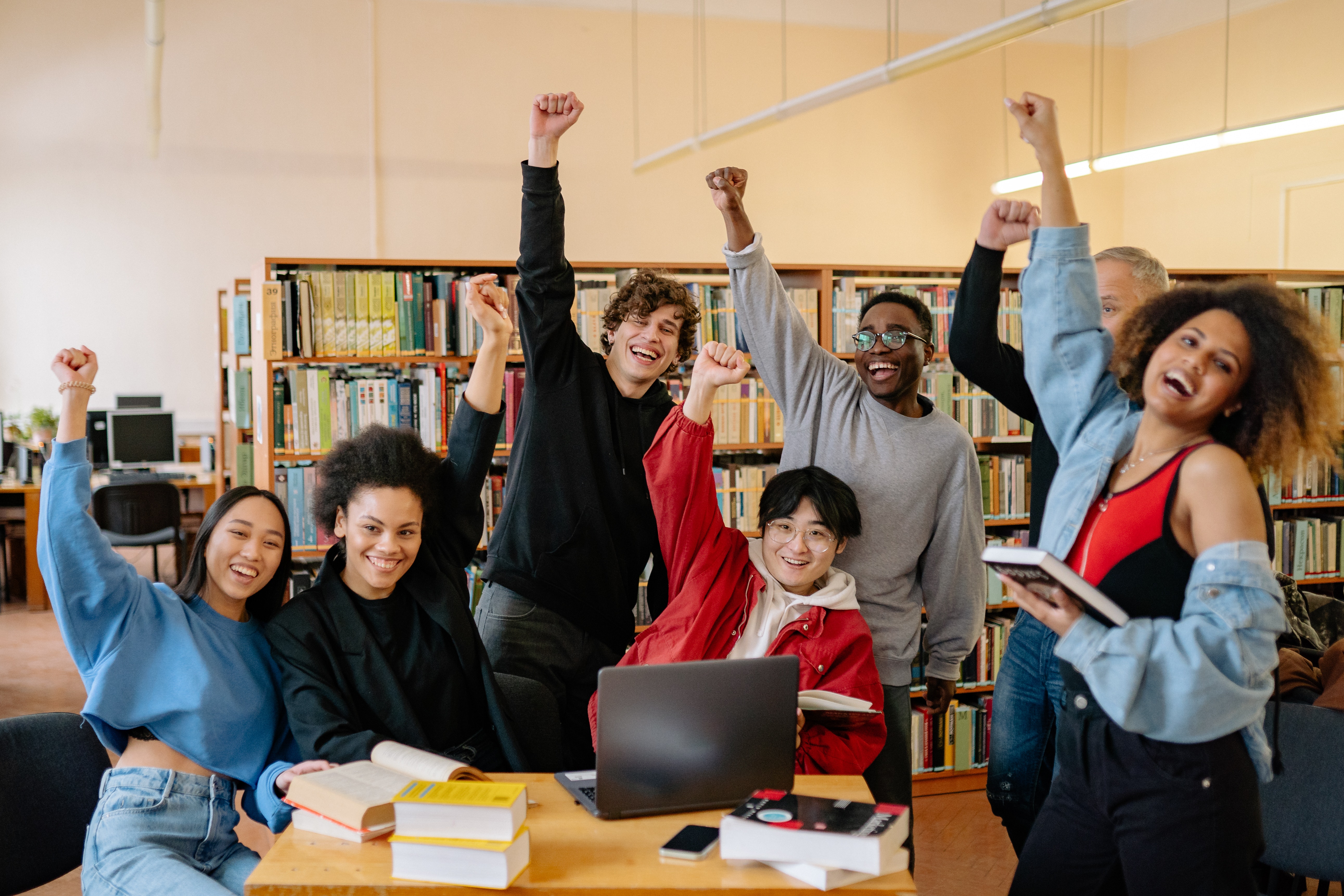 students celebrating with their hands in the air