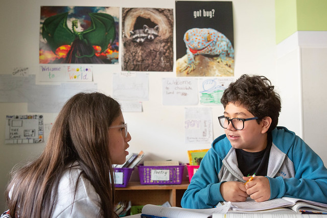 two students talking in classroom