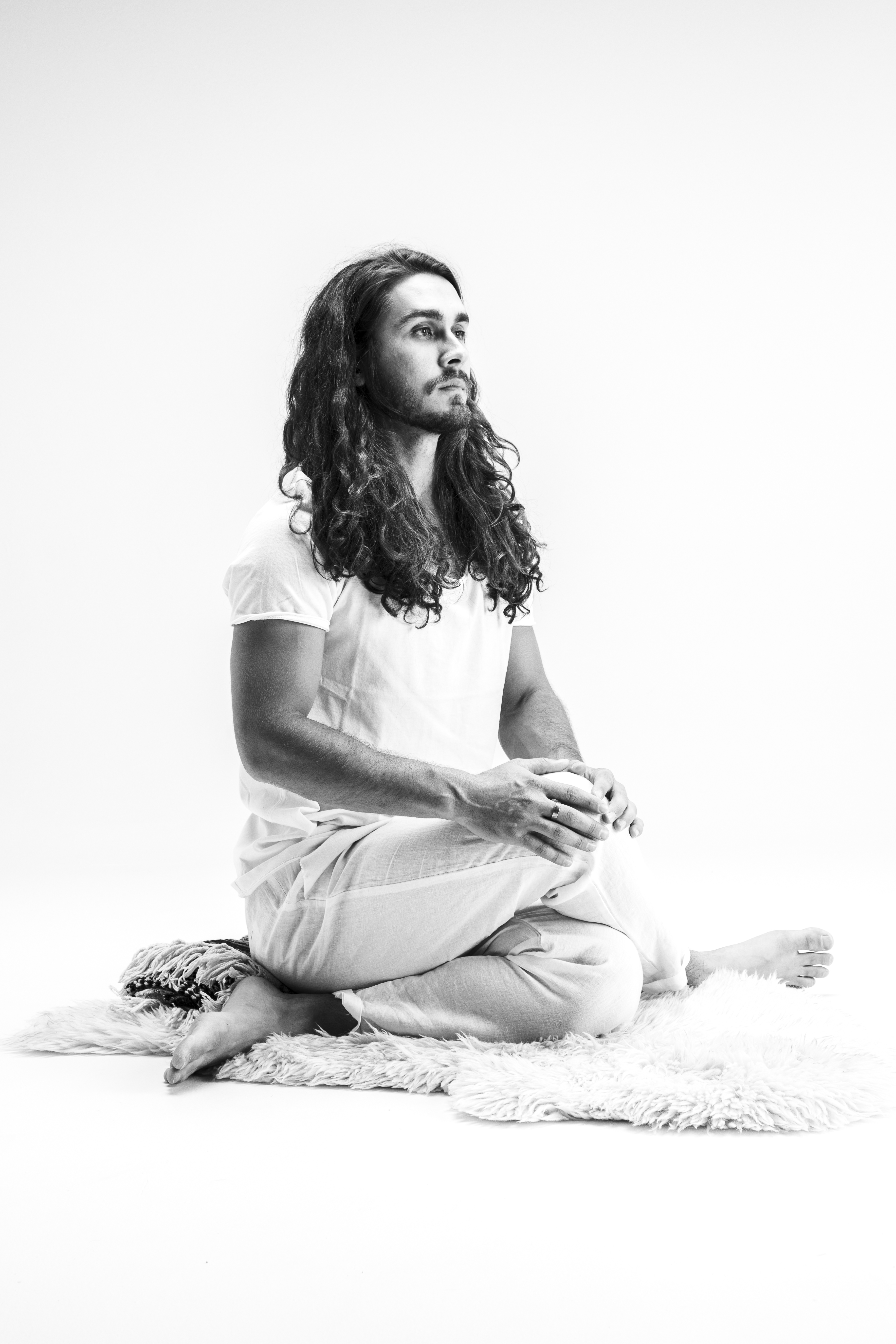 black and white image of yin yoga teacher Raymond Tapia demonstrating shoelace pose