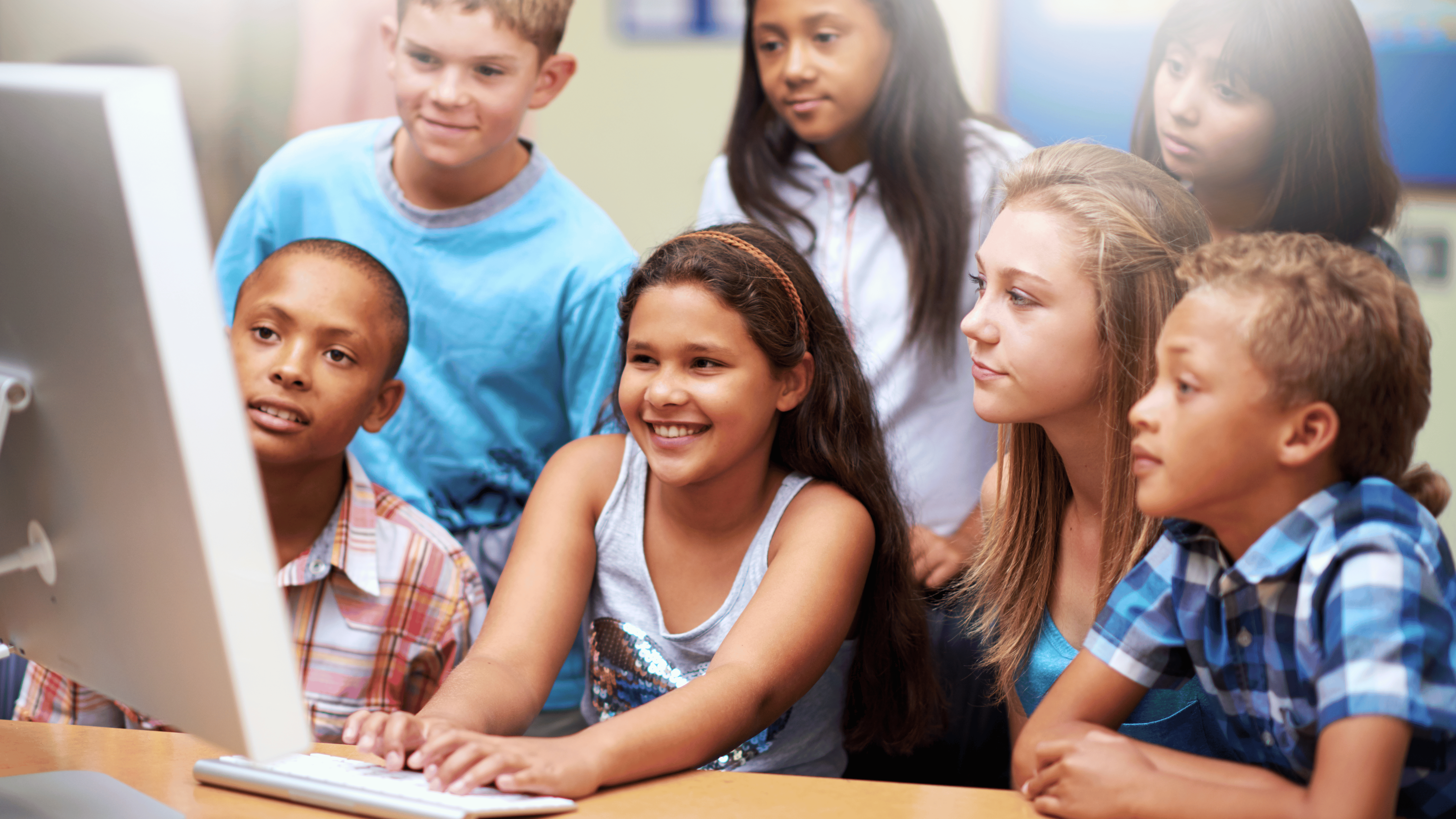 students and teacher around computer