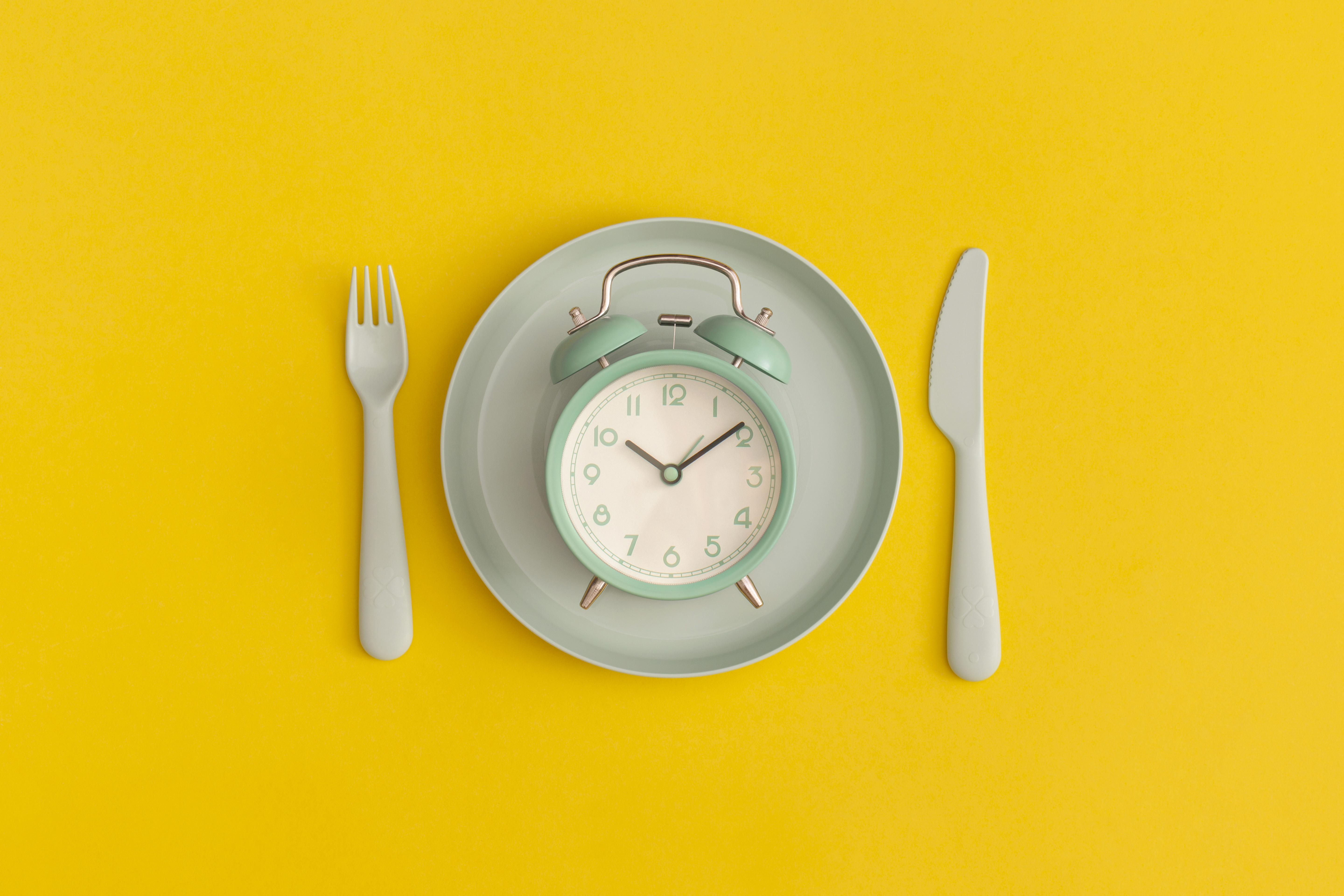 clock on a plate with knife and fork