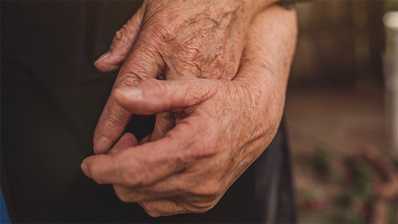 Two clasped hands with wrinkled skin