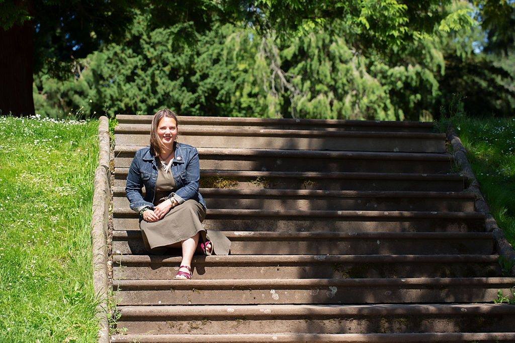 Image of lesley sitting on some steps in the sunshine 