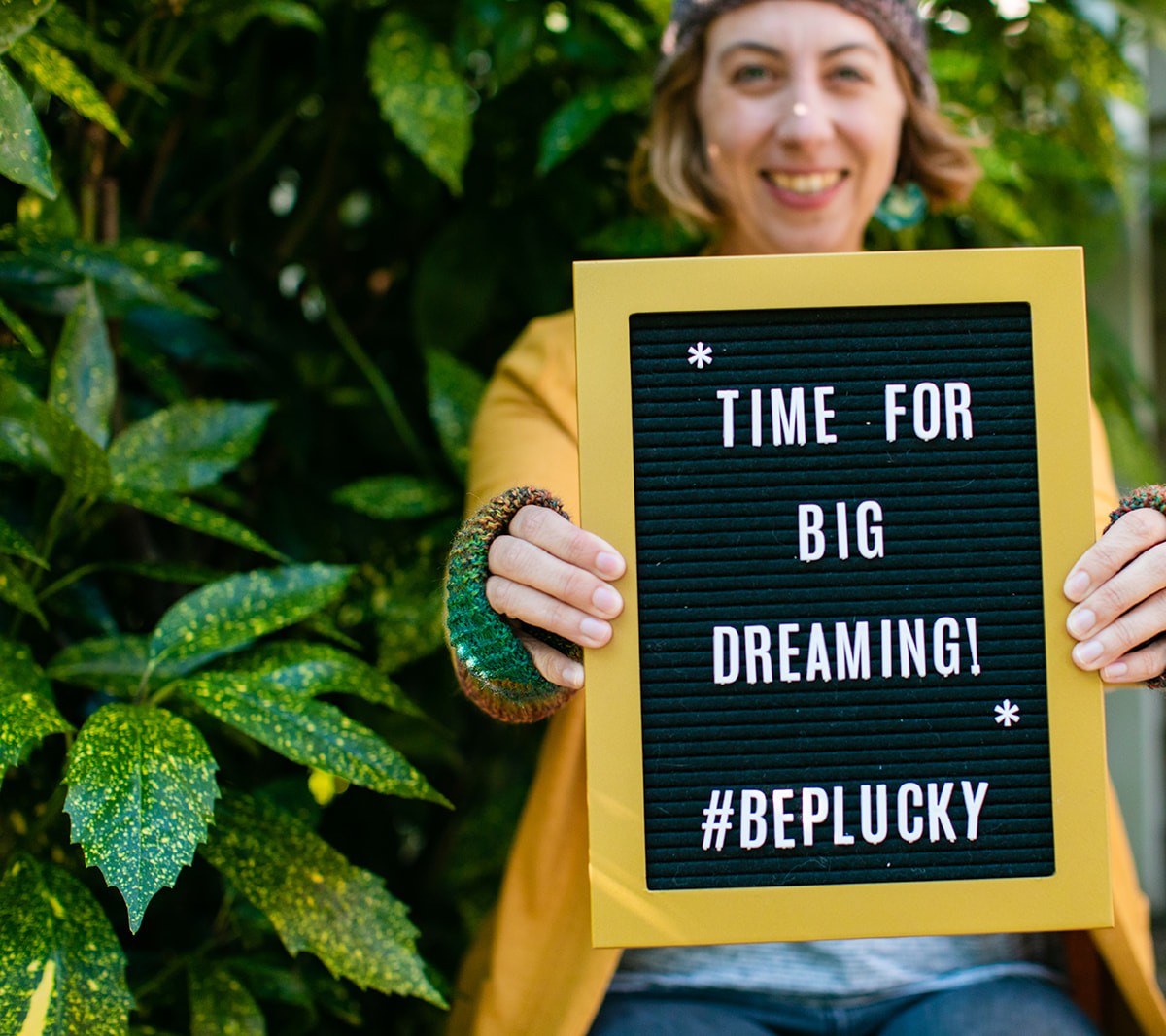 Coach Jen Dary holds a sign that says "Time for Big Dreaming" #BePlucky