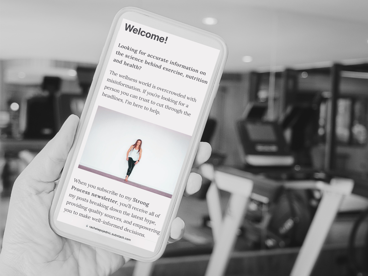 hand holding smartphone with image of fitness and nutrition expert Dr. Rachele Pojednic in front of a gym with exercise equipment