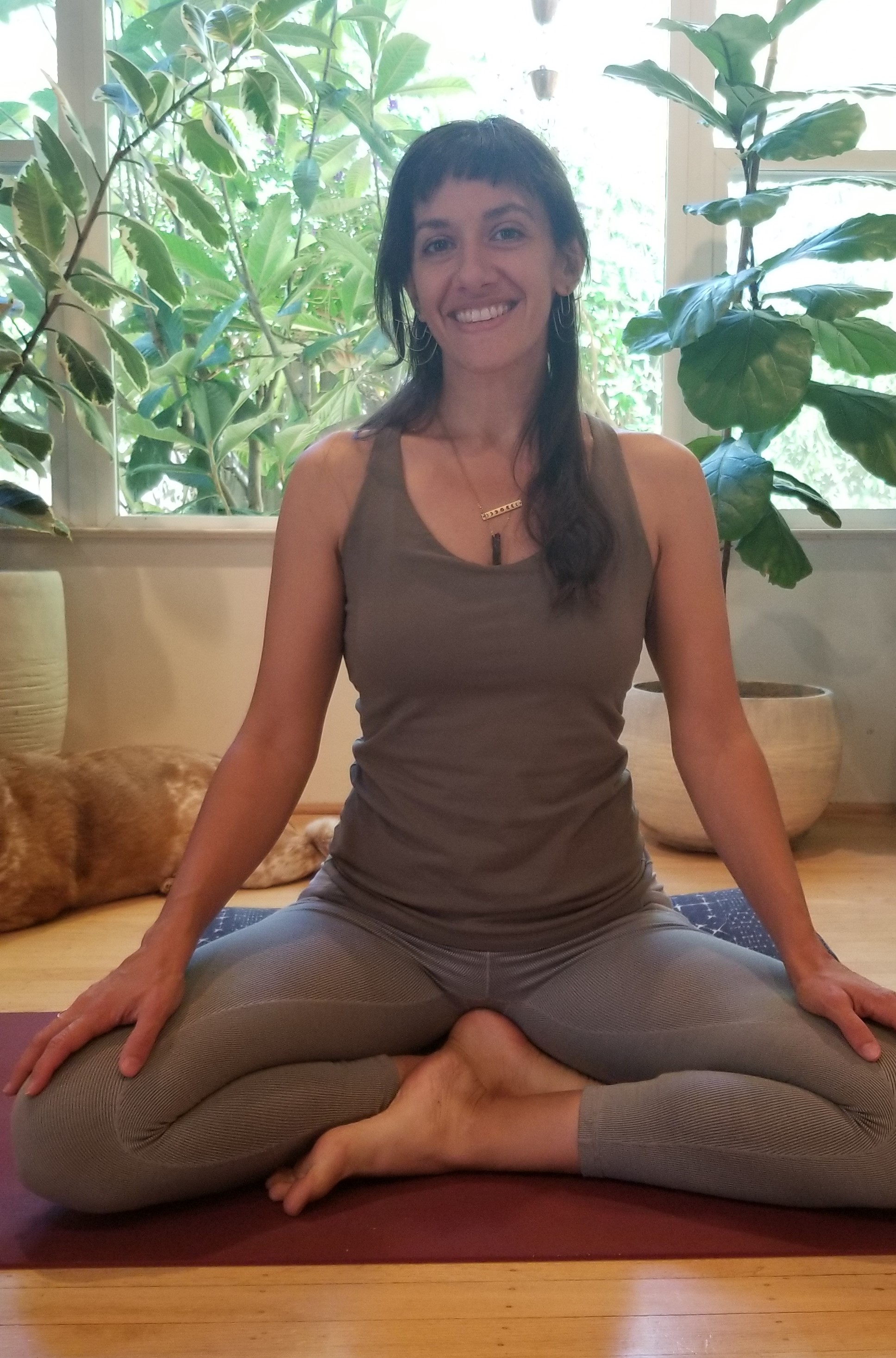 Amy seated on her yoga mat