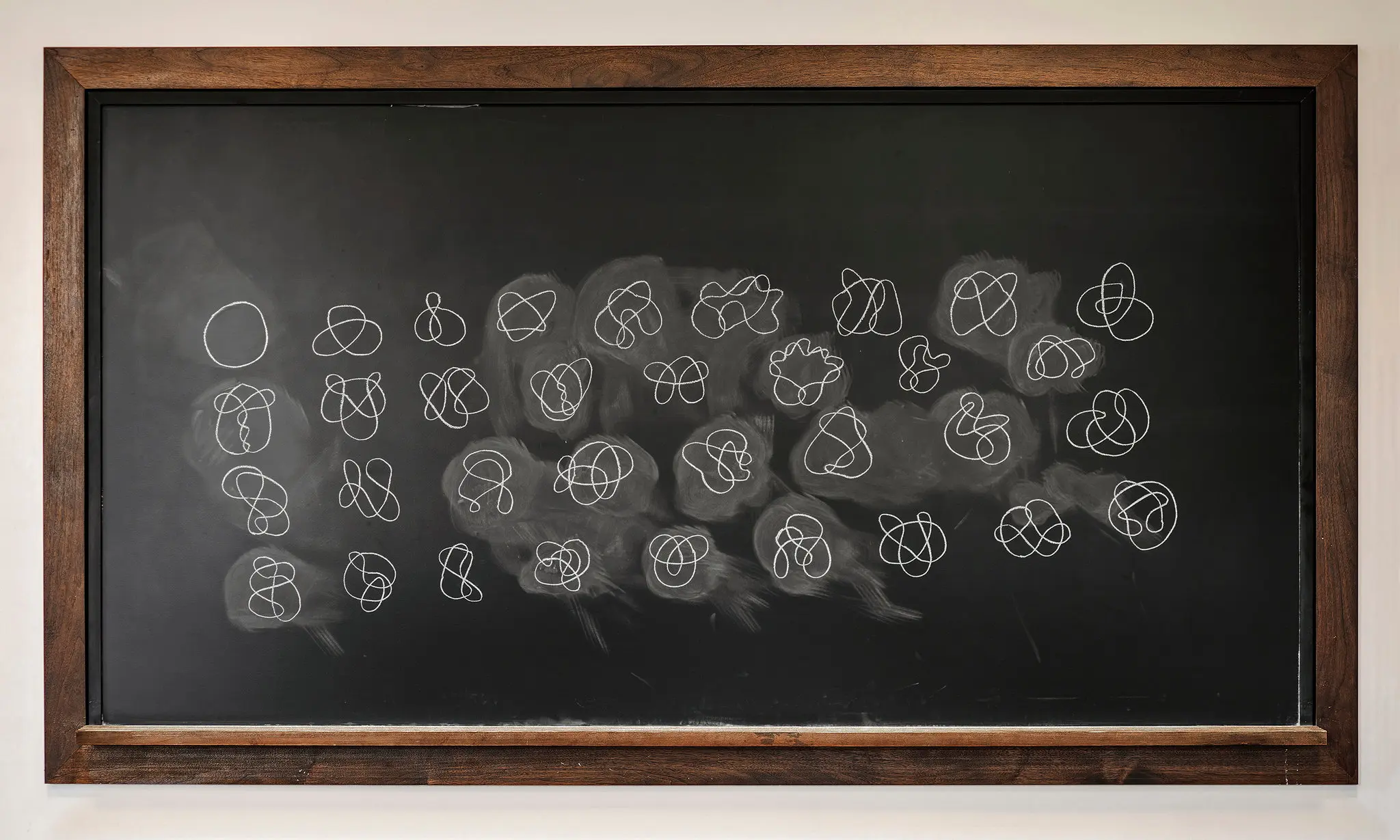 Chalkboard with squiggles written on it.