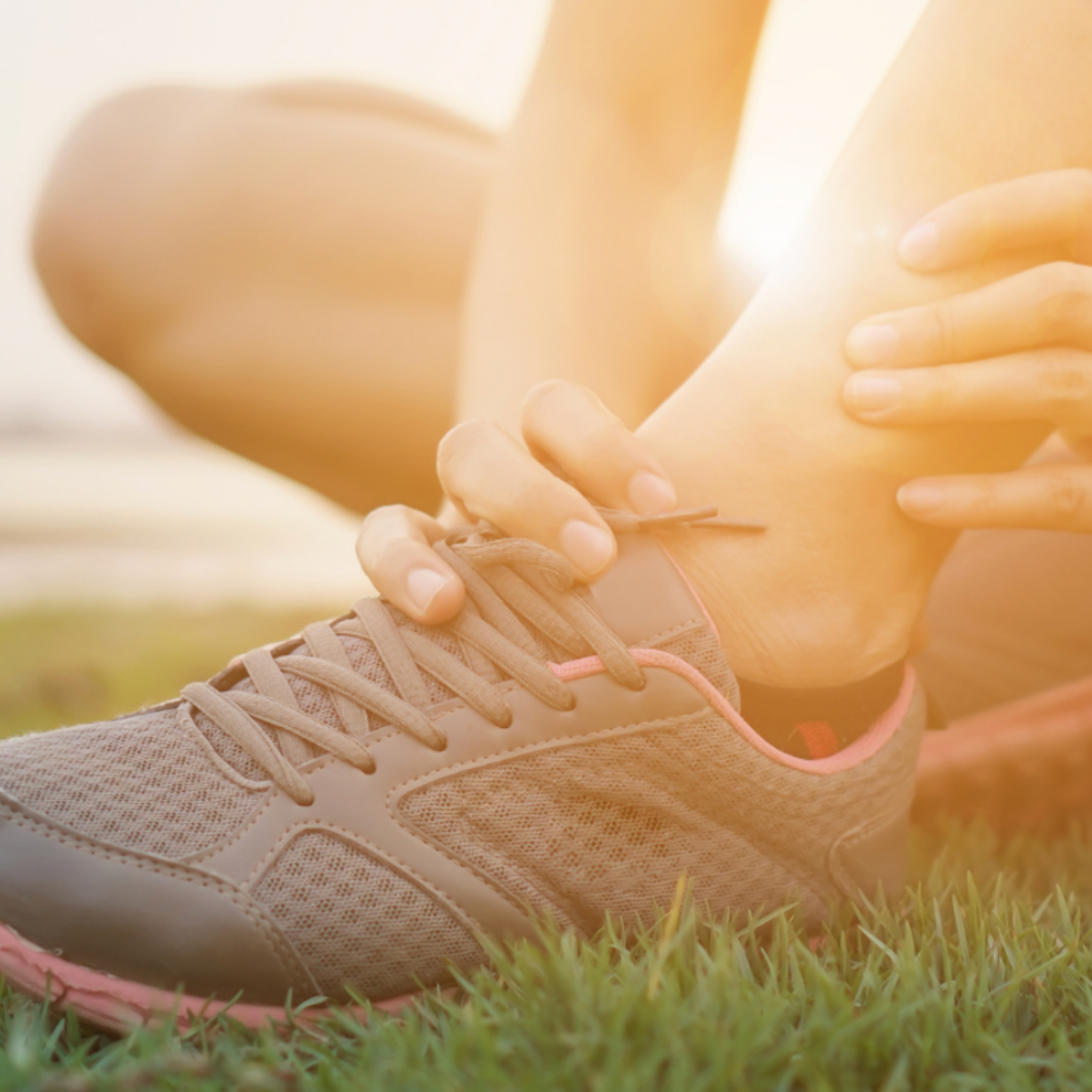 Person holding her ankle in sunshine.