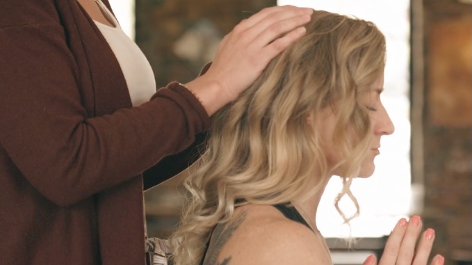 woman laying hands on top of woman head