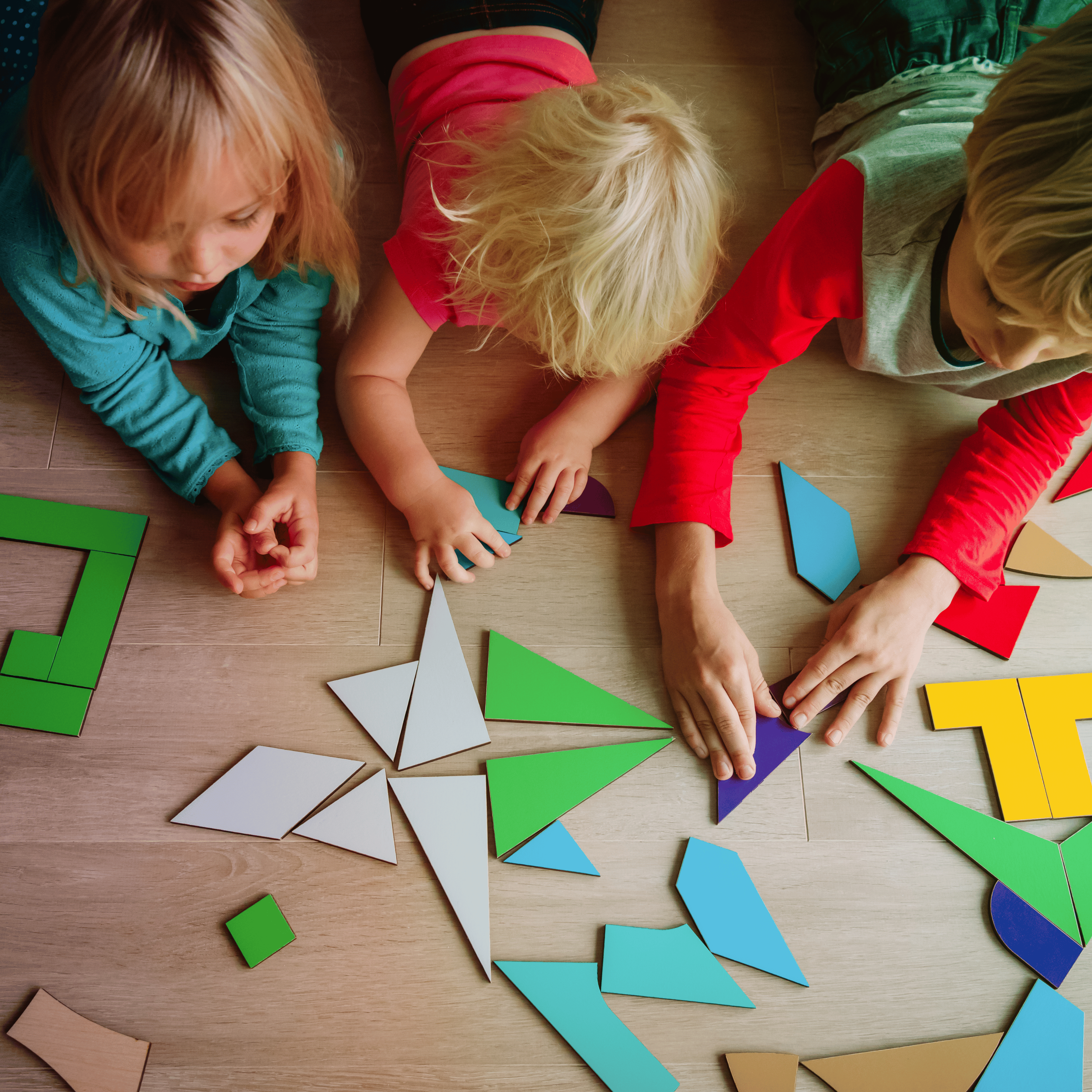 kids using tangram shapes on the floor