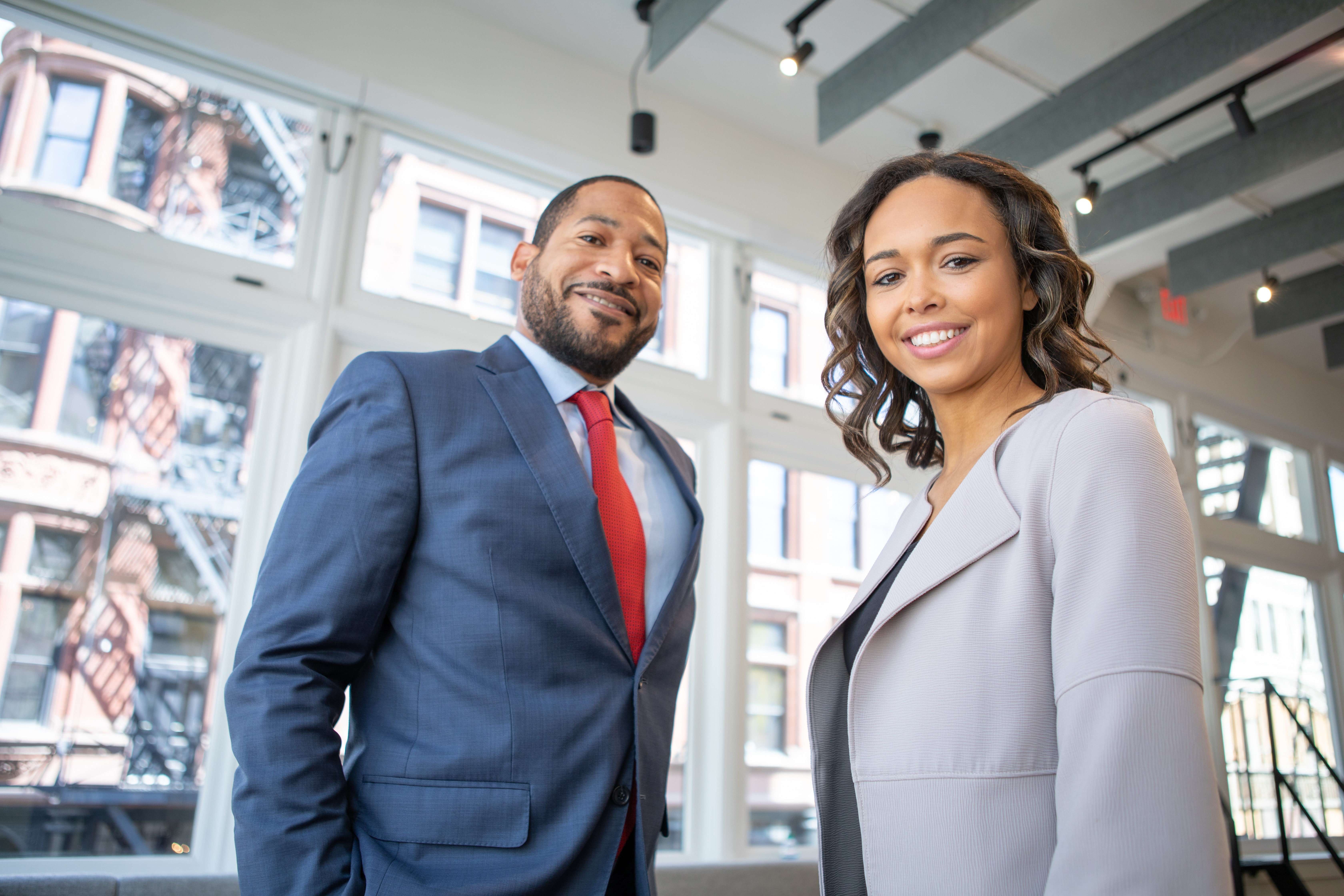 A business man and woman in suits and smiling