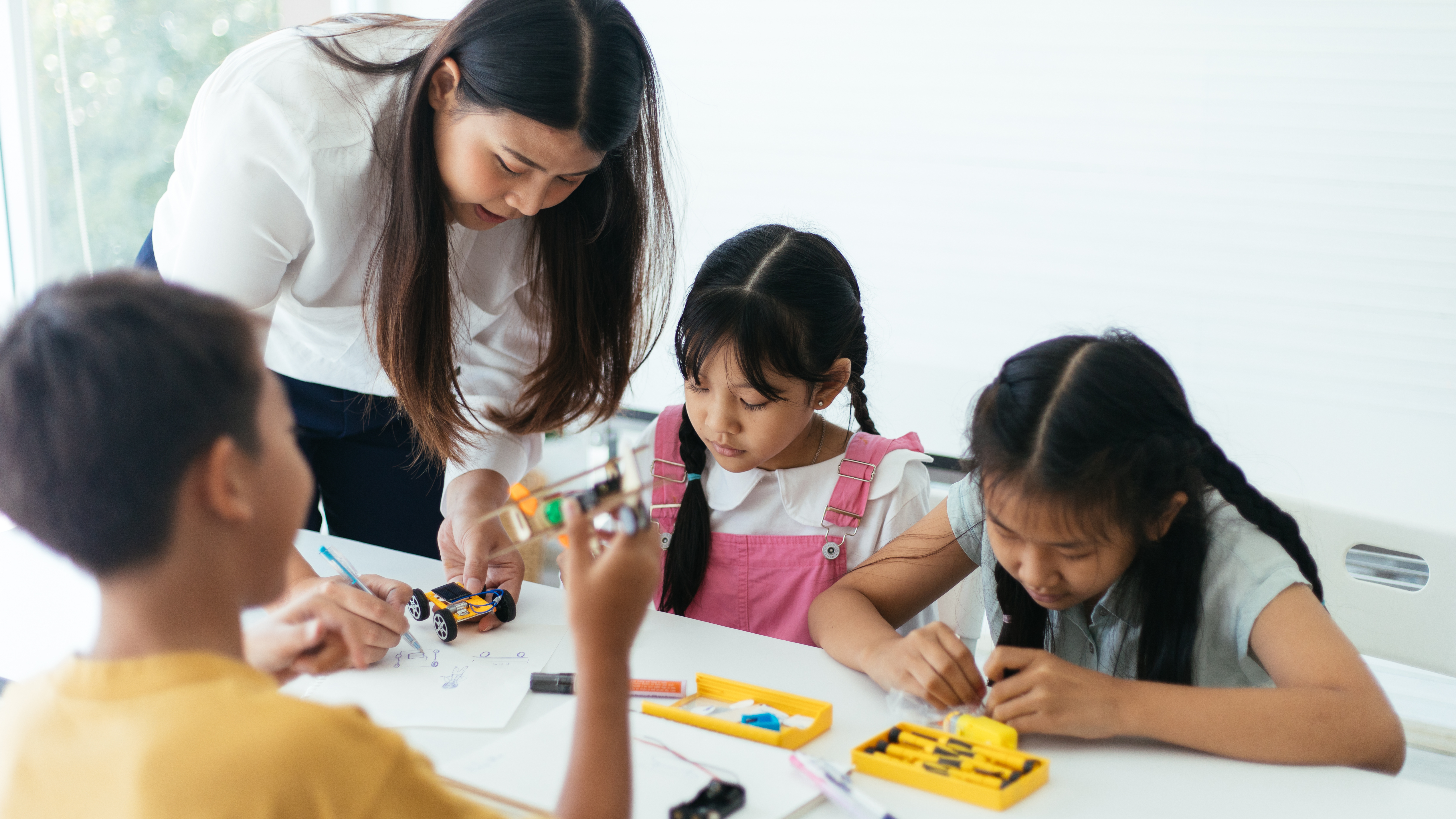 teacher working with students on creative project