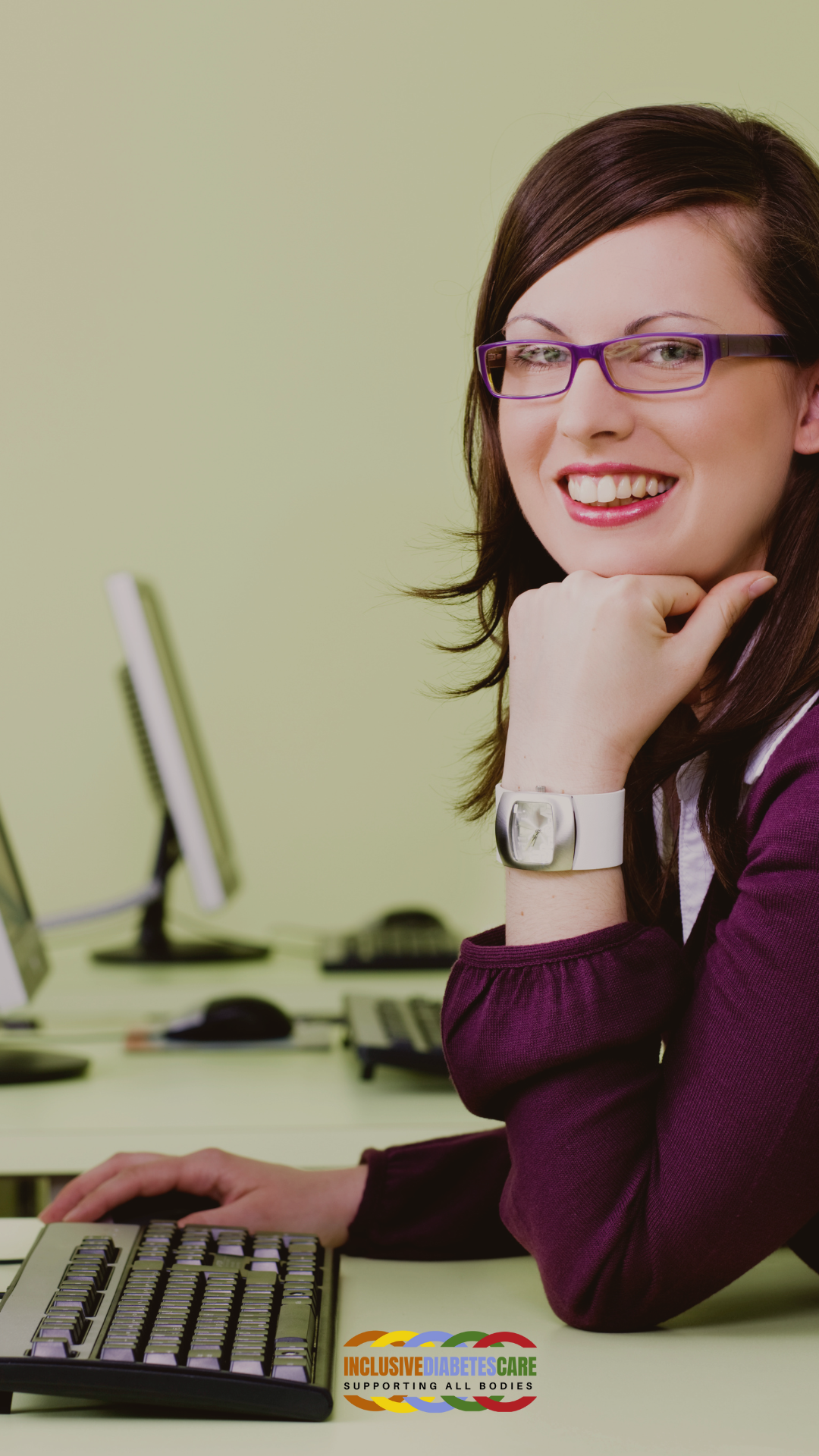 Smiling White woman at a computer, head resting on her hand.