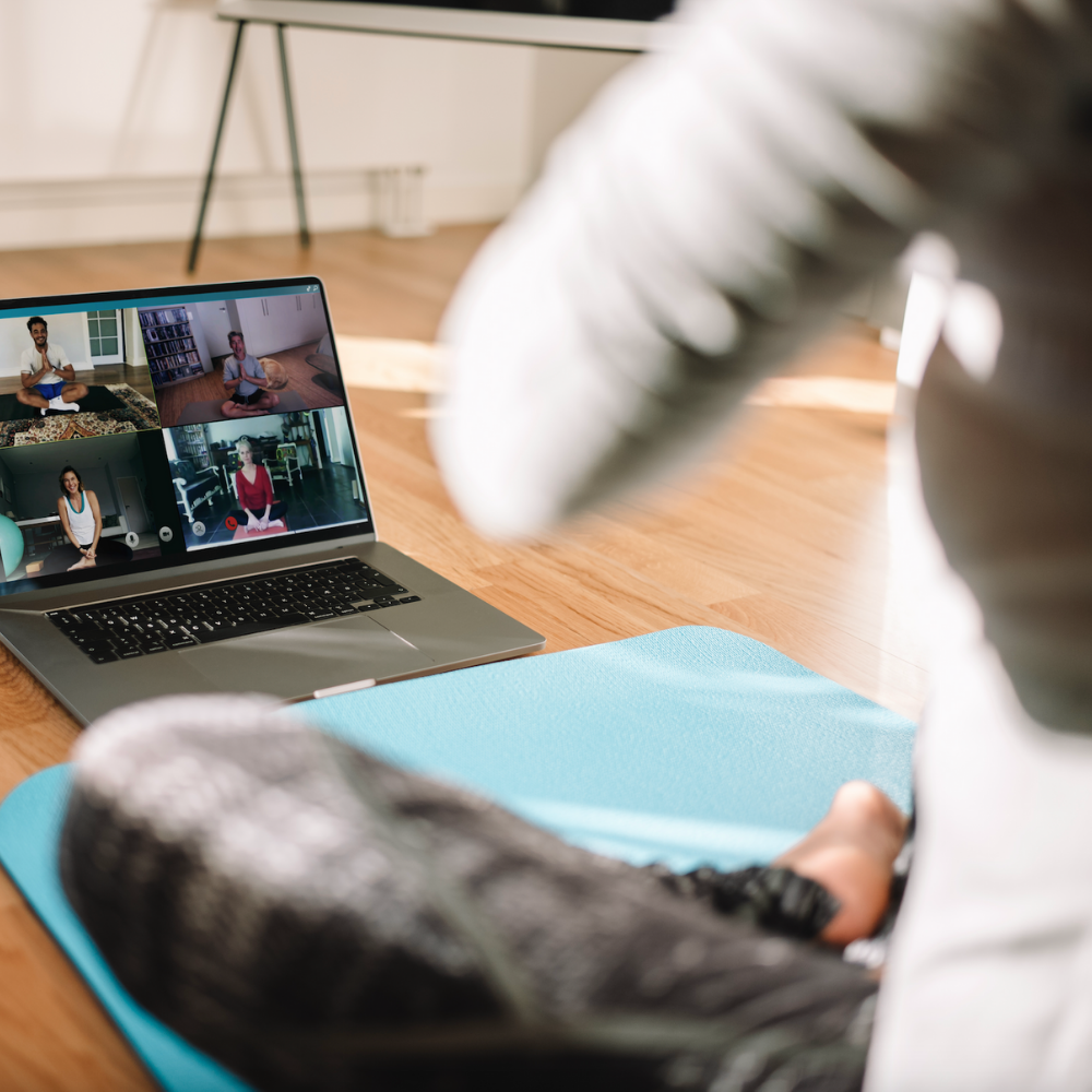 Woman meditates in front of computer with zoom class