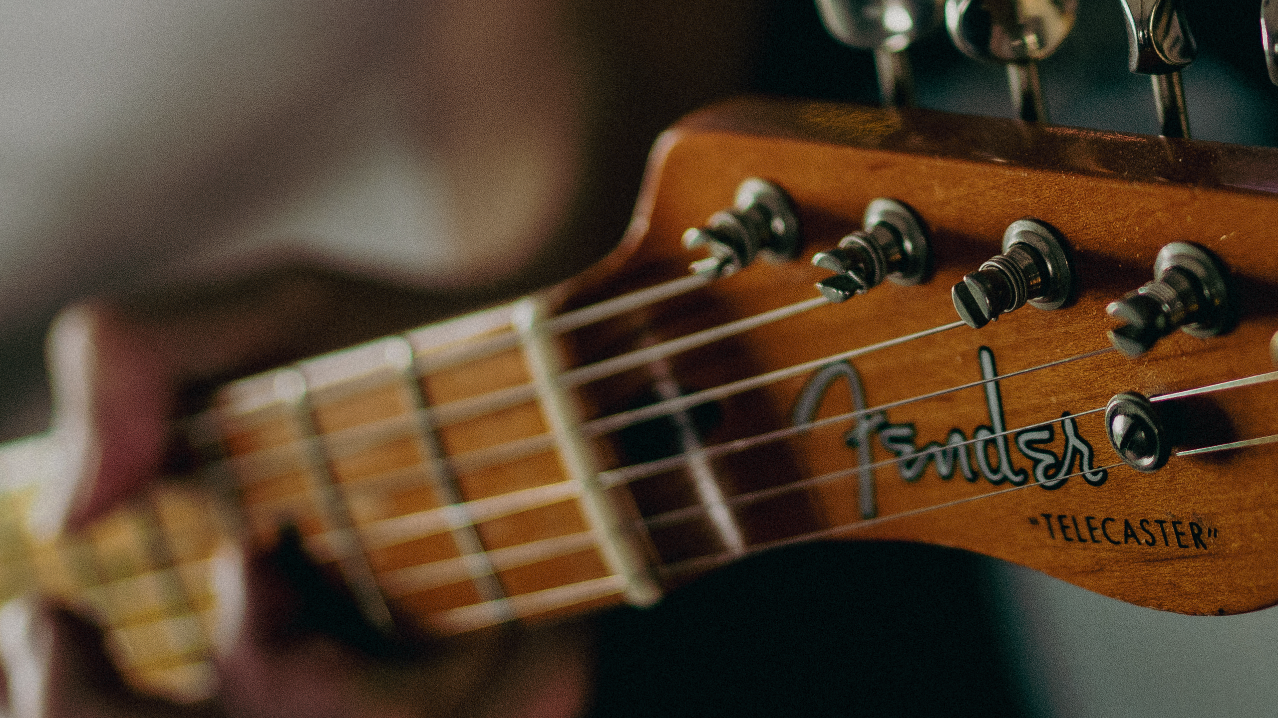 Close up of a Telecaster guitar fingerboard with fairy lights in the background