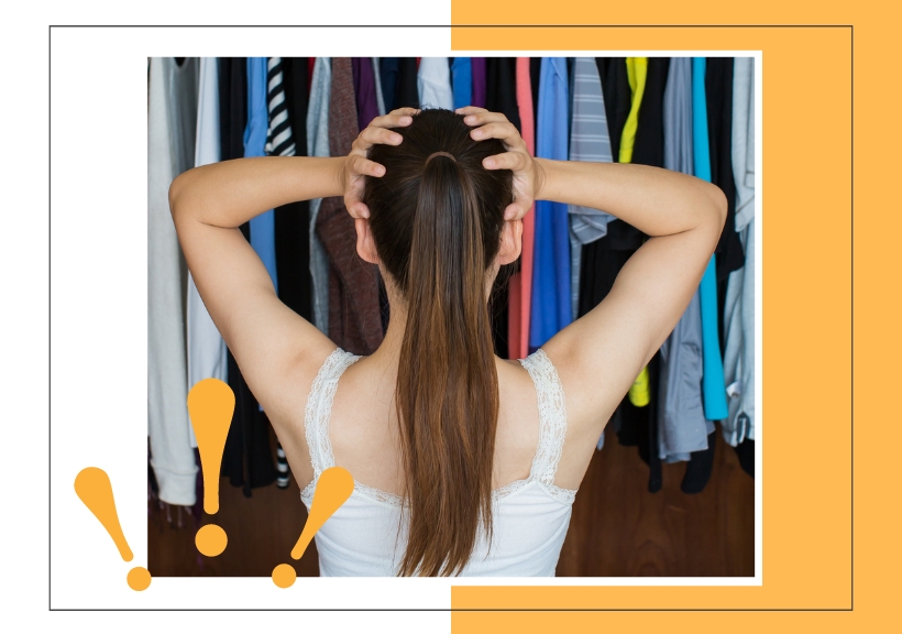 woman with her hands on her head standing in front of her closet