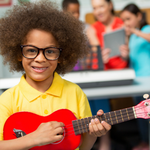 child with red ukulele