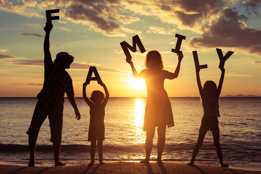 A shadow outline of a family holding the letters spelling Family