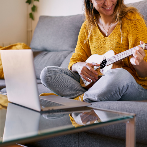 adult learning ukulele with laptop