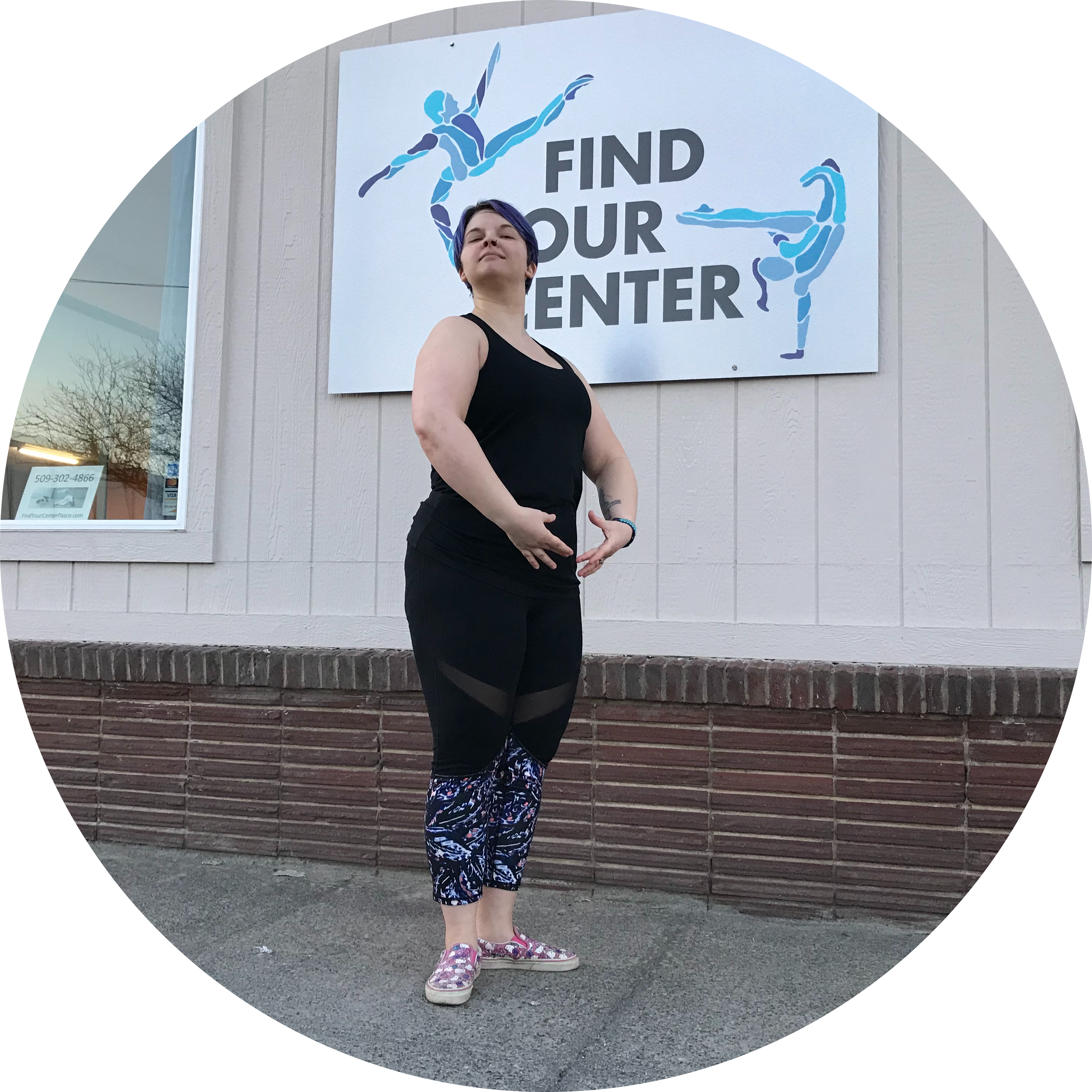 A beginning adult ballet student stands proudly in first position on a sidewalk in front of a sign with the Find Your Center logo