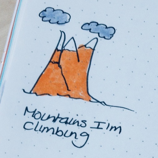 an image of a hand drawn mountain wit dark clouds above and the words: Mountains I'm climbing