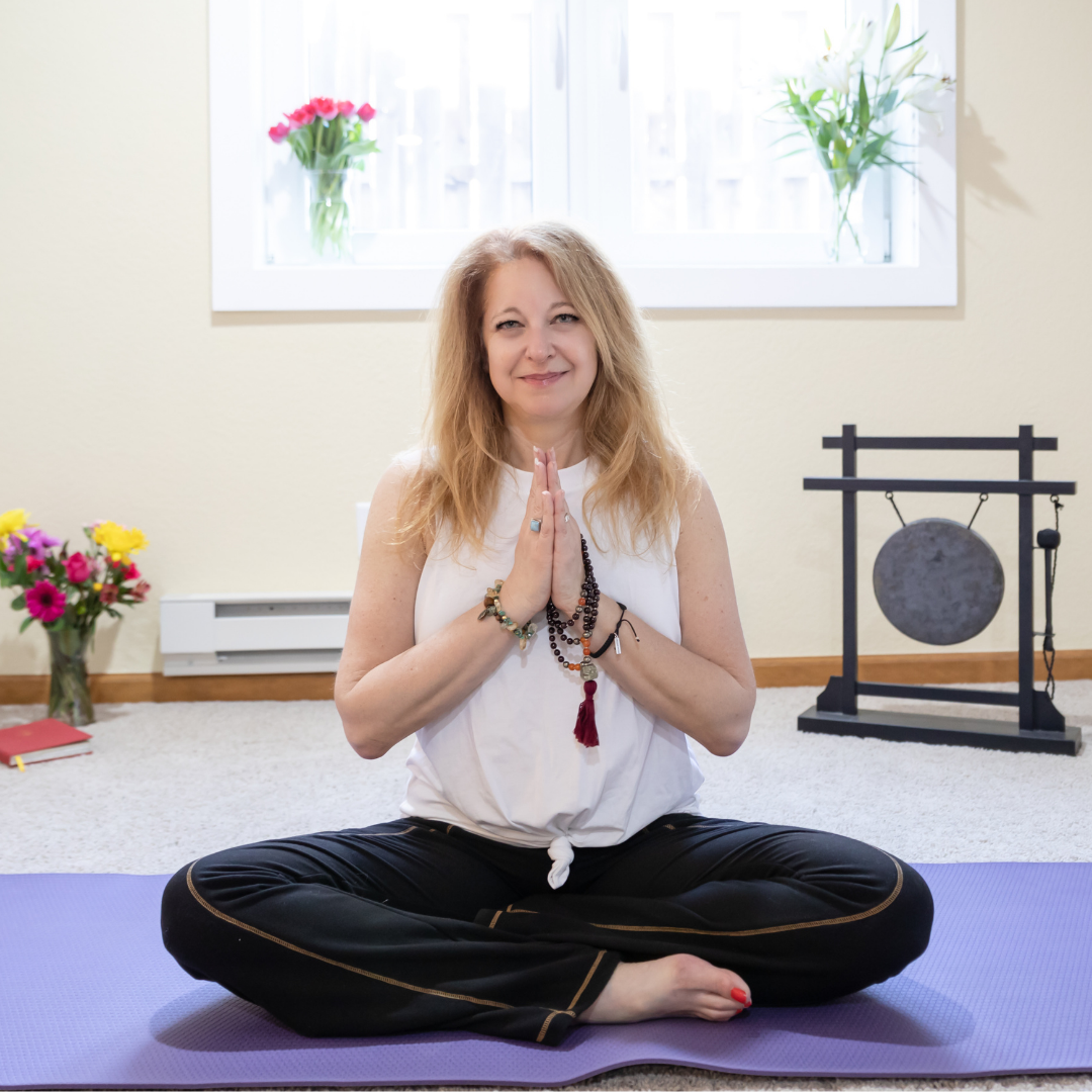 woman meditating with flowers and gong