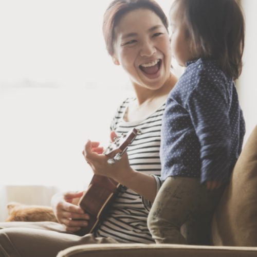 mum playing ukulele to child