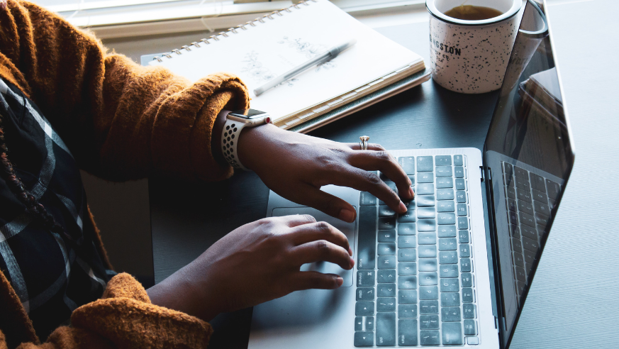 Woman typing an article on her laptop