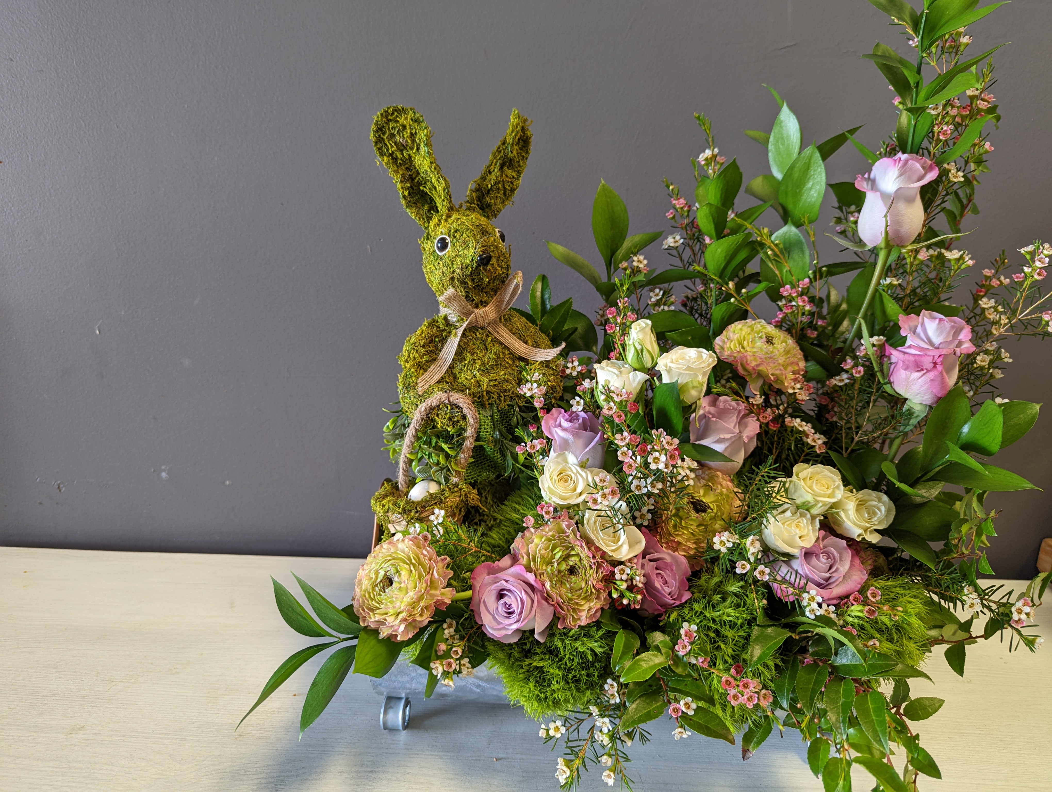 Moss covered mini rabbit surrounded by fresh flowers
