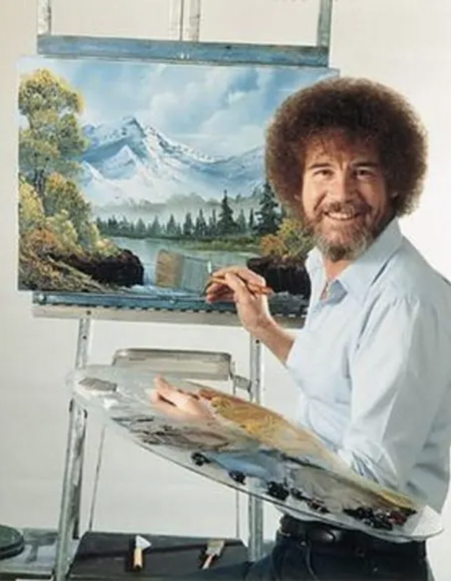 classic Bob Ross image, fuzzy-haired man painting &quot;happy little trees&quot; while smiling at us