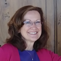 Image of Suzanne Pitner, TeacherWriter LLC in front of a wooden door.