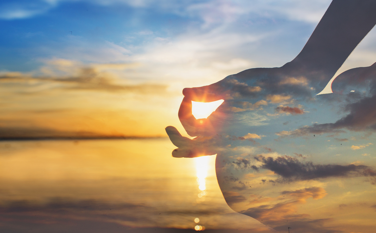 Sunset with meditation hand posture silhouette on the right side