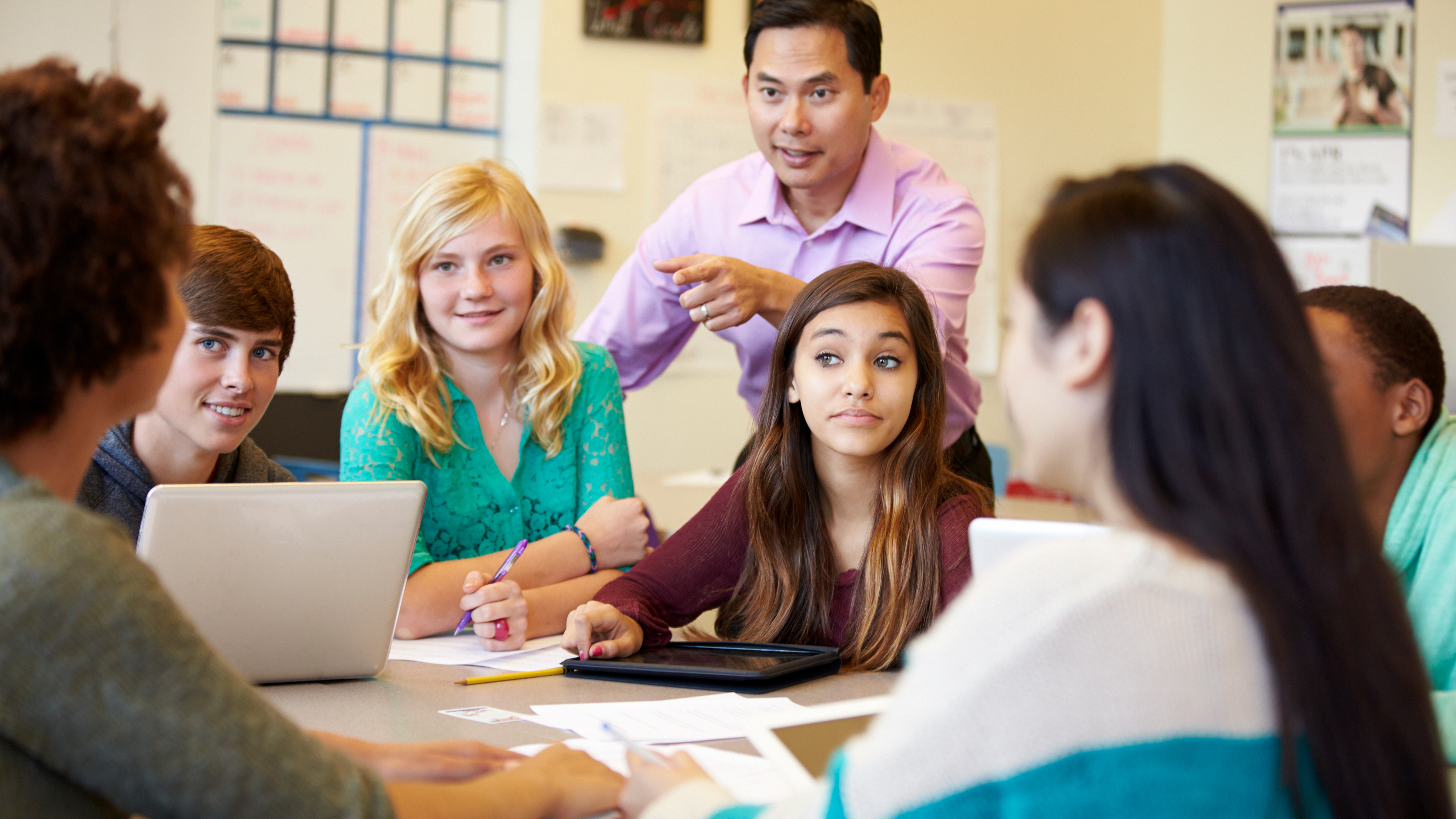 teacher working with students who look hopeful