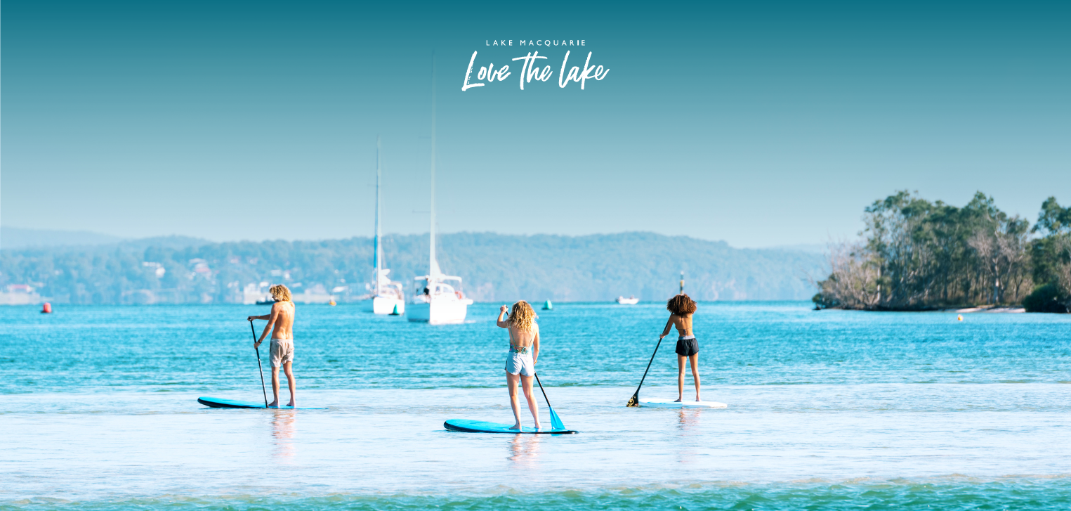 Visitors stand up paddle boarding within Lake Macquarie 