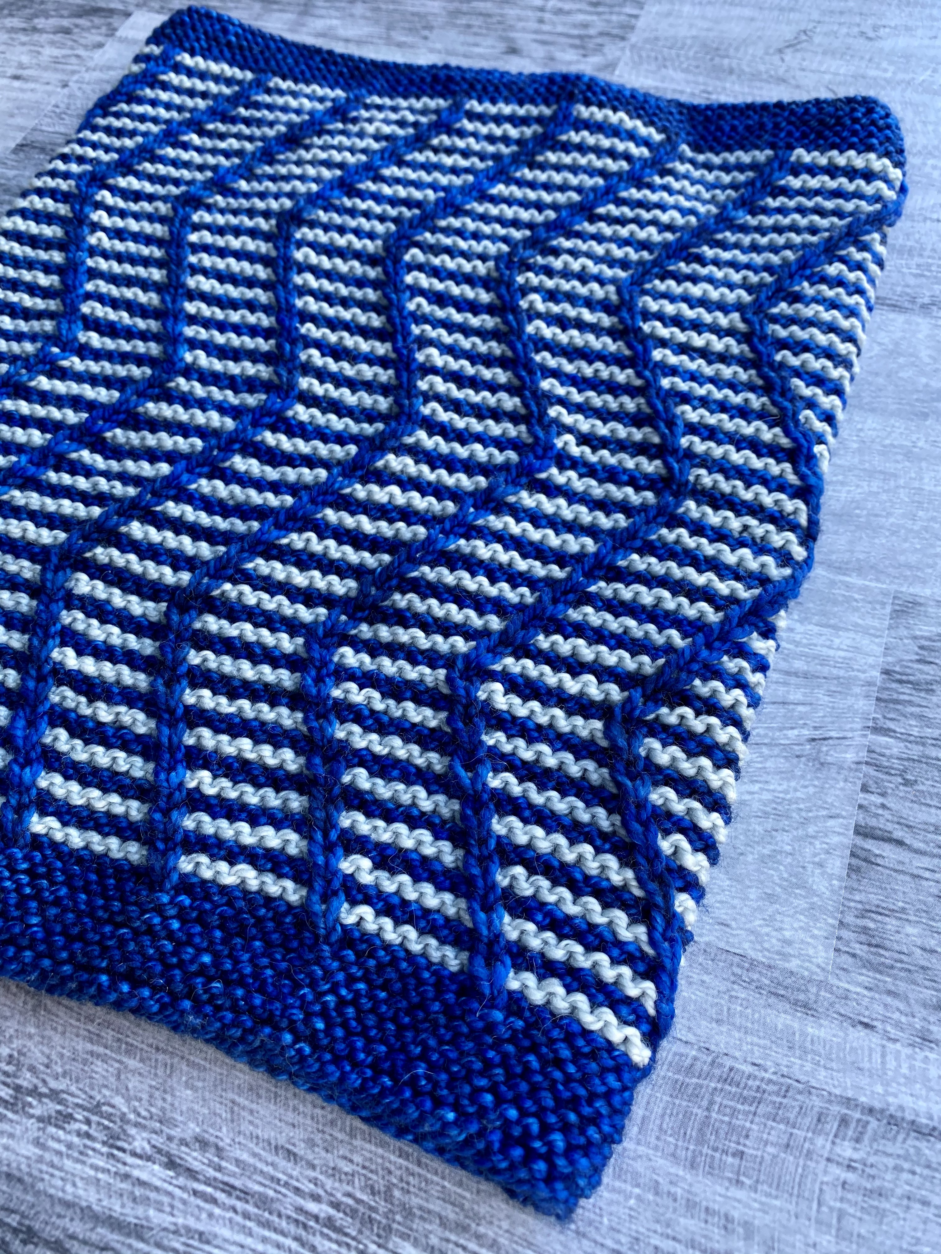 Close up of knitted cowl with blue and grey stripes